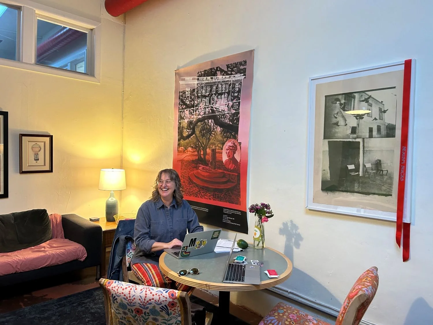 Woman sitting a small round table, working on her laptop