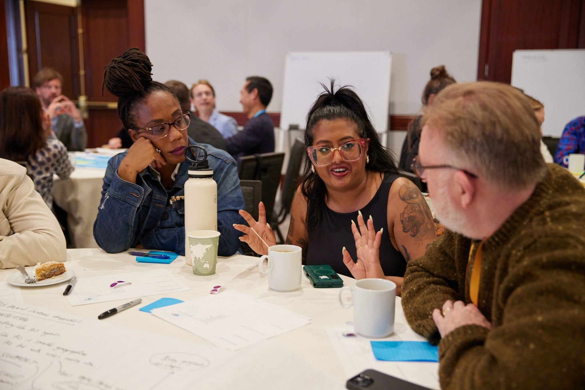 Three people talk at a round table at an event