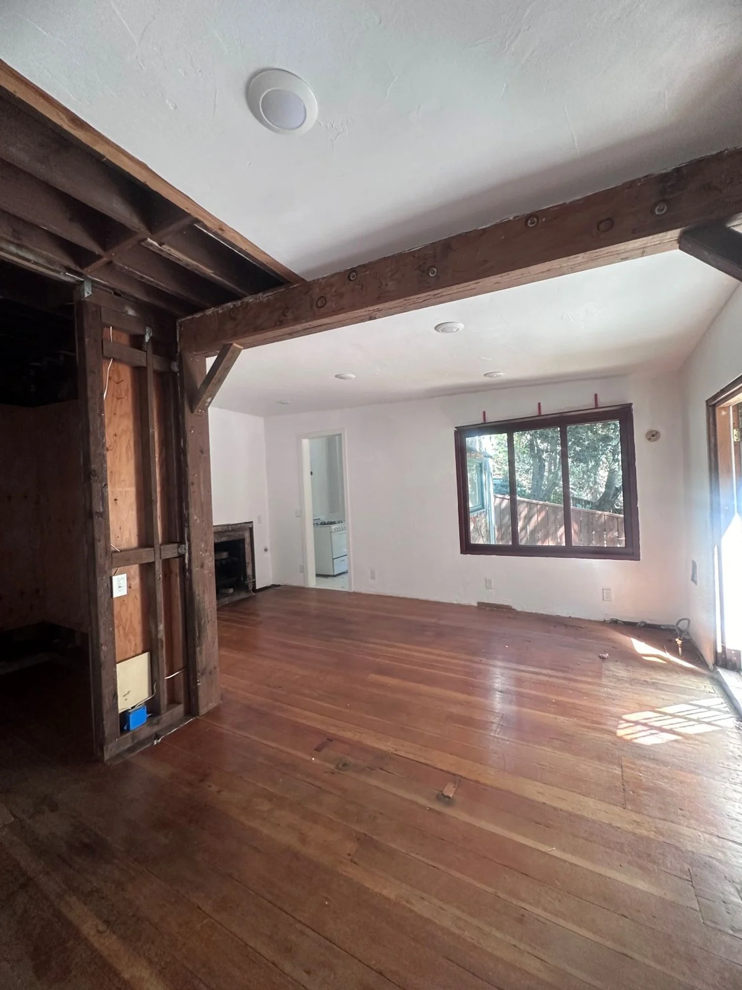 Empty room with exposed ceiling beams and joists
