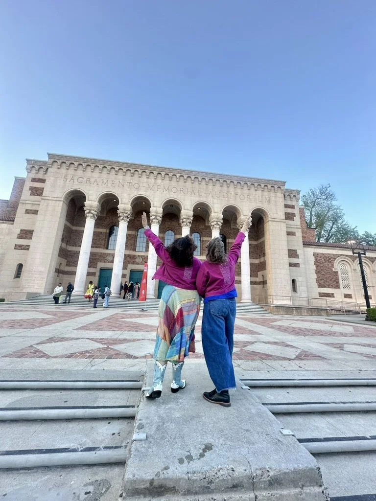 AST staff members facing away from the camera with one arm each in the air