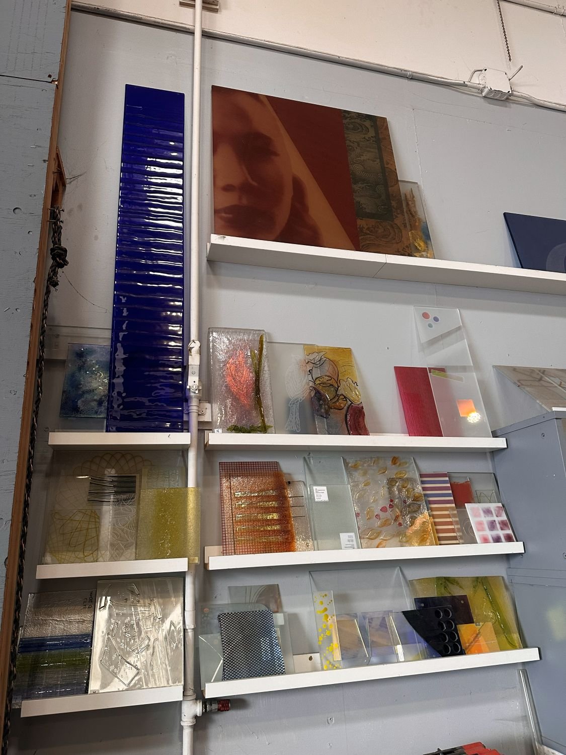 Glass artwork on shelves in an art studio