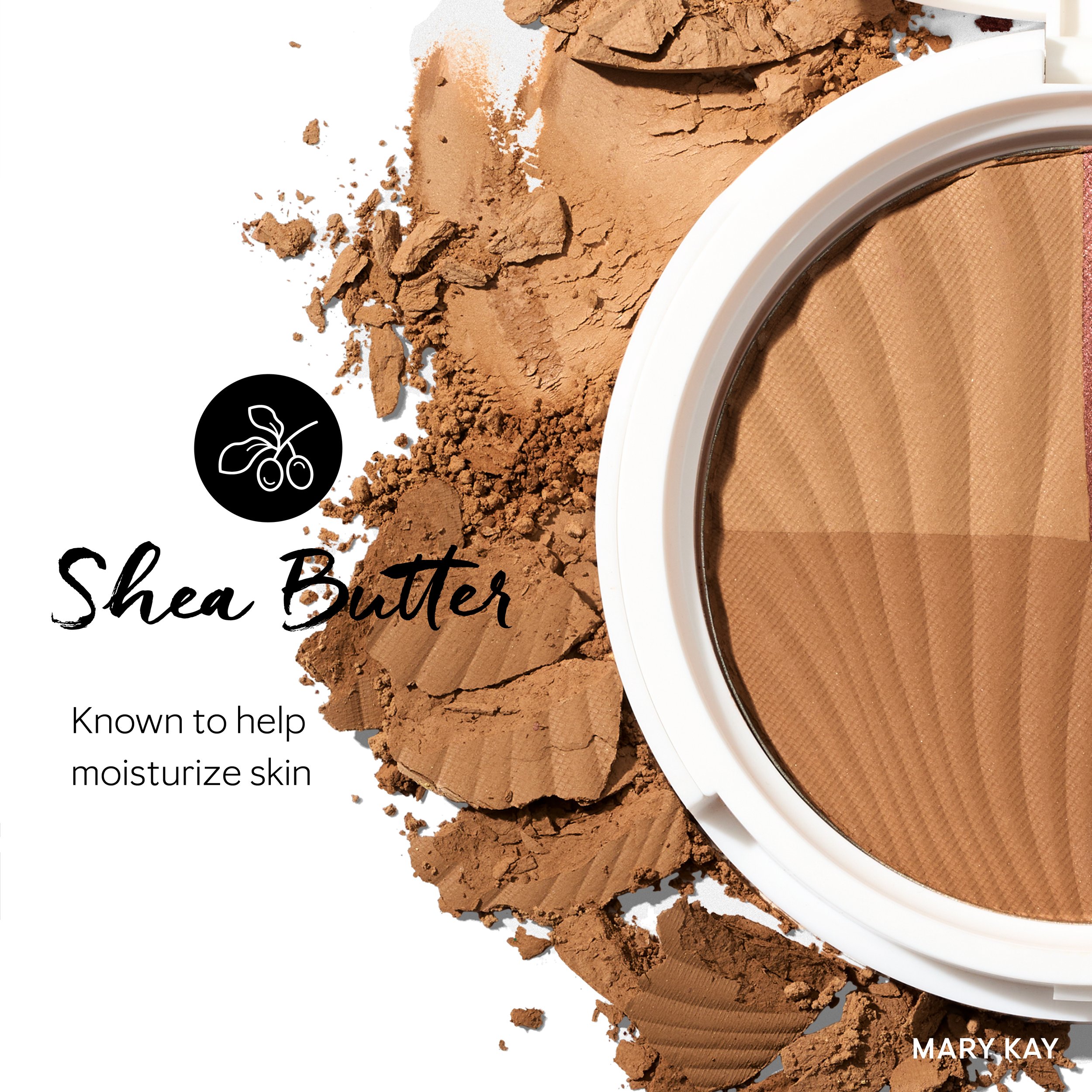 Open compact of Sheer Sheer Brown pressed powder with crushed powder scattered around, labeled as Shea Butter and promoting skin moisturizing benefits, by Mary Kay.