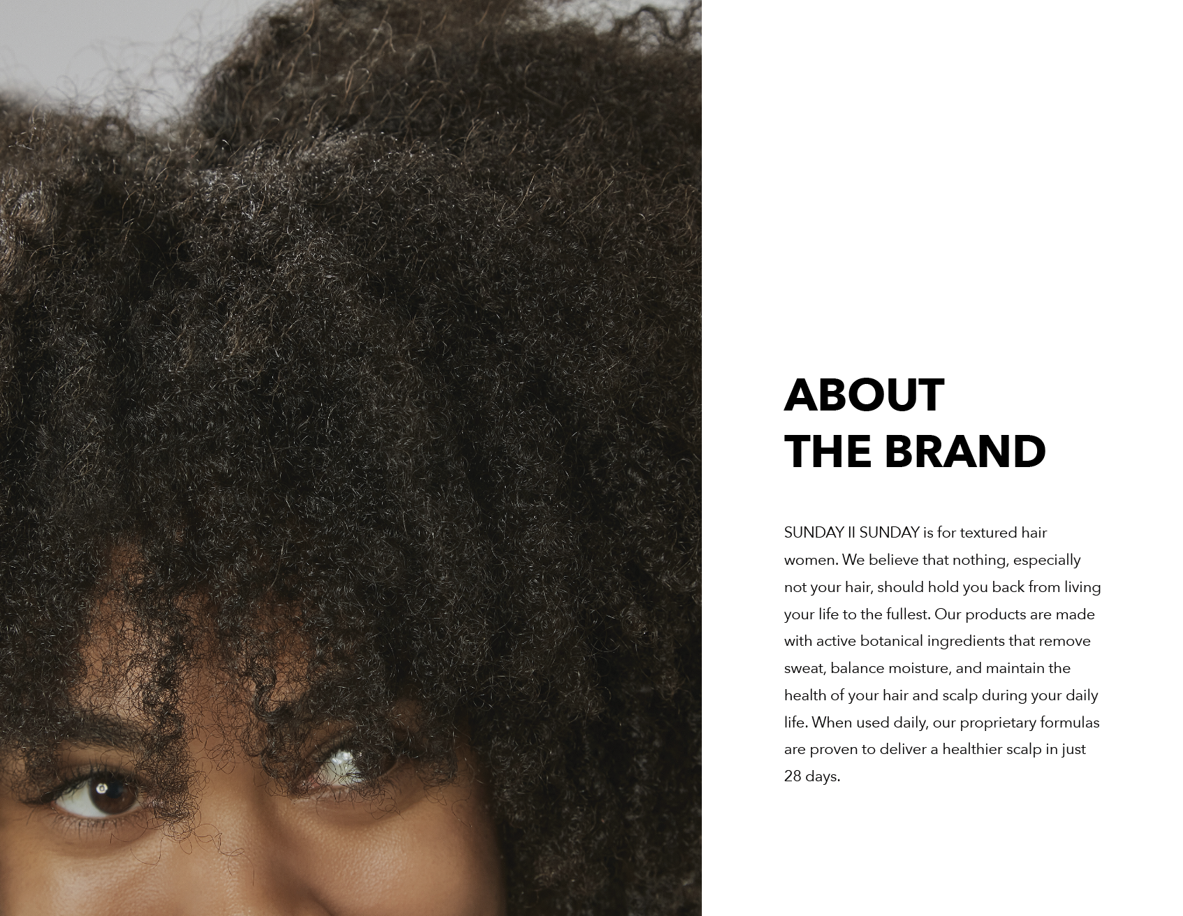 Close-up of a woman's face with textured, curly hair covering part of her forehead and eyes.