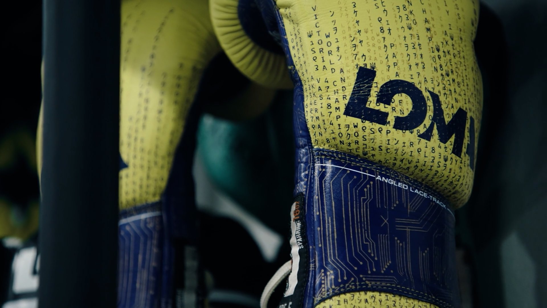 Close-up of a tennis shoe with yellow and blue design, featuring a pattern resembling a circuit board and the word 'WILSON' prominently printed on the side.