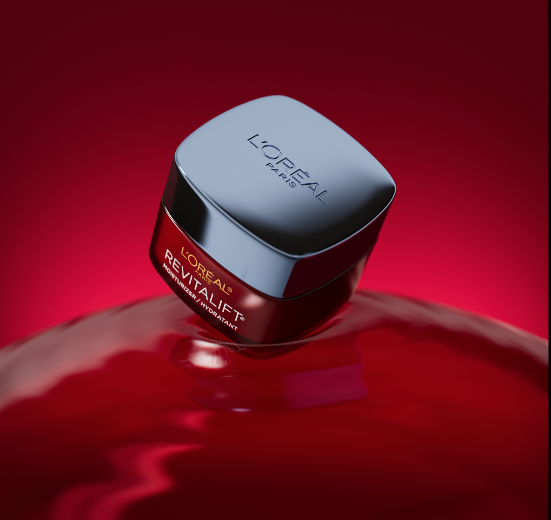 L'Oréal Revitalift Moisturizer hydrating cream jar floating on a red liquid background.