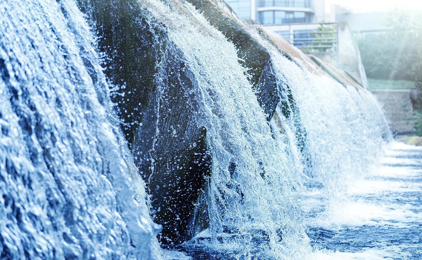 Close-up of water cascading over rocks at waste water treatment plant. Modern urban wastewater treatment plant.