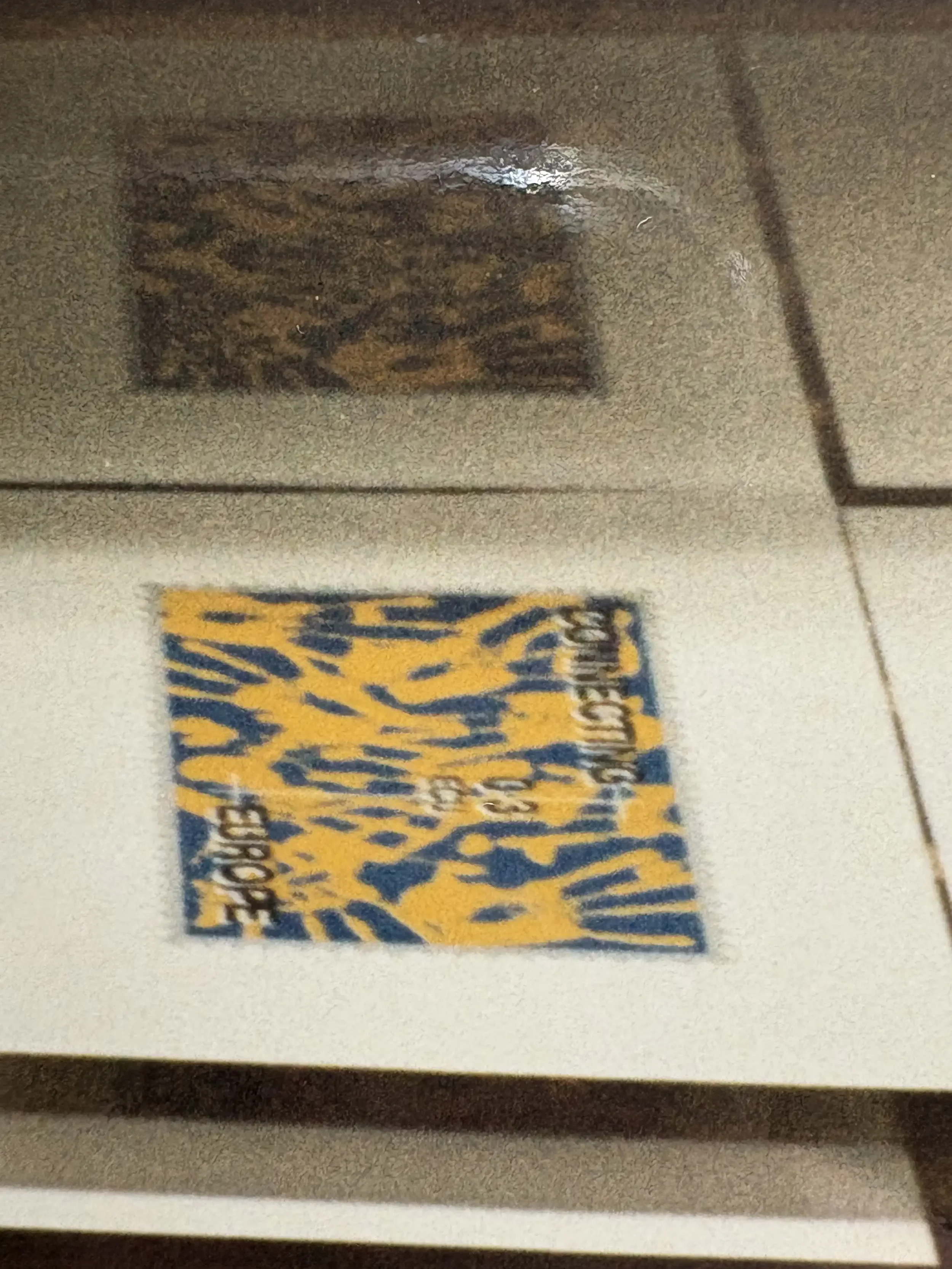 A yellow and blue hand print stamp design on a drying rack.