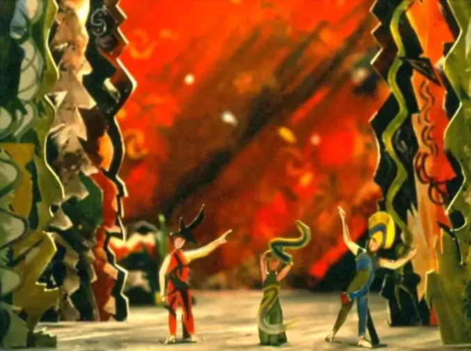 Animated scene with three characters in colorful costumes performing on stage, surrounded by figures with intricate designs against a fiery orange and red background.