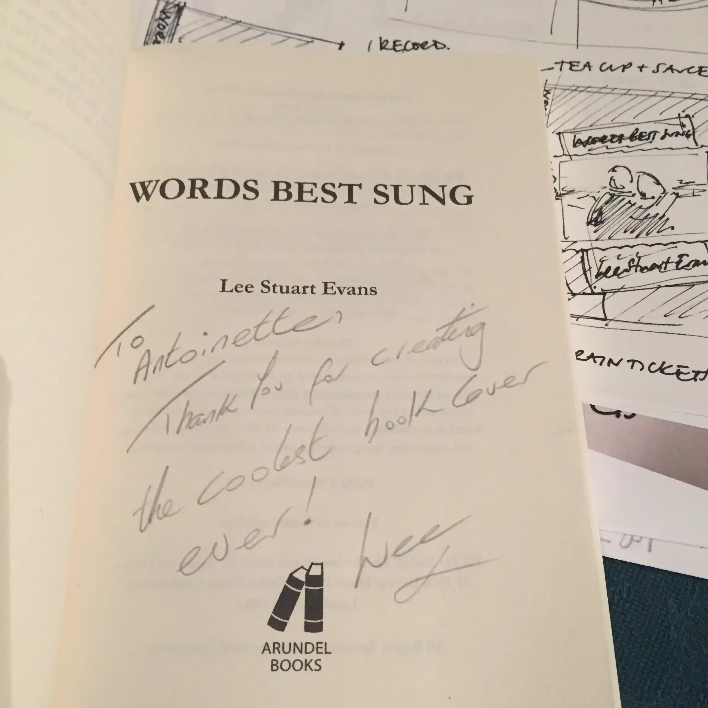 Page from a book titled "Words Best Sung" by Lee Stuart Evans, with a handwritten note thanking Antoinette for creating the coolest book cover, and the Arundel Books logo at the bottom.
