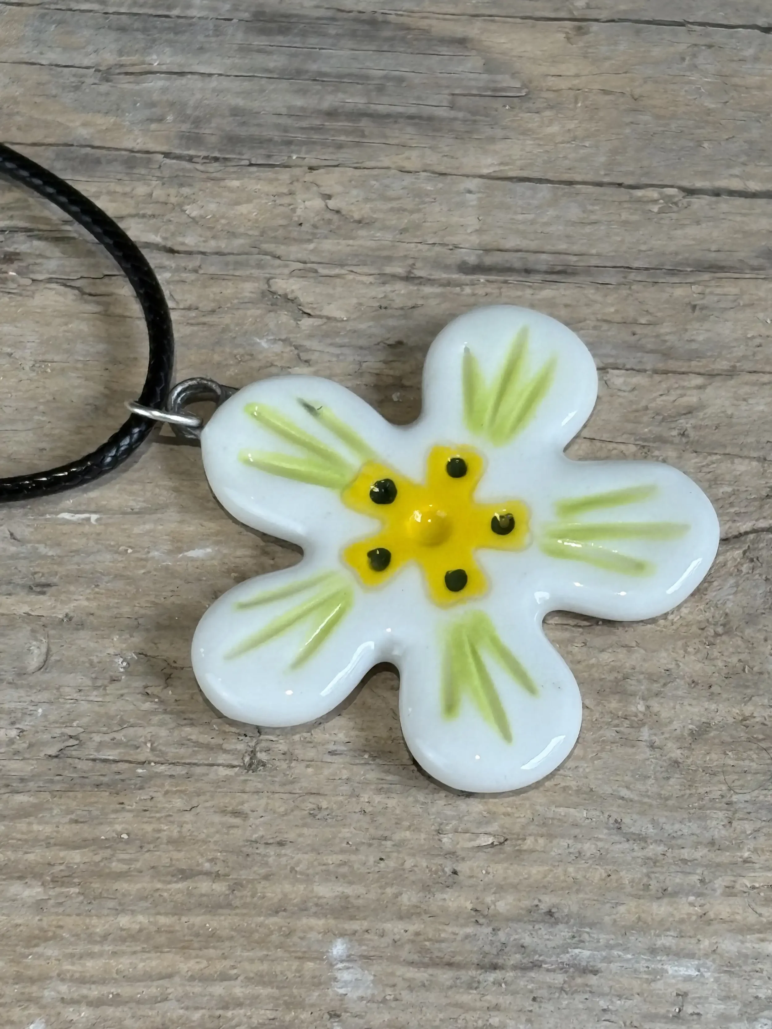 Flower pendant on wooden surface.webp