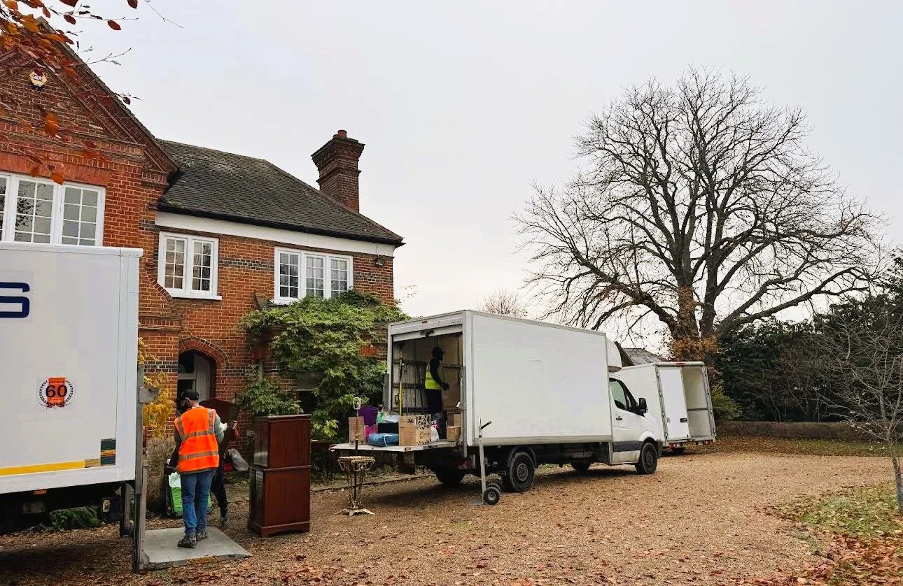 Movers unloading belongings from a moving truck at a residential home