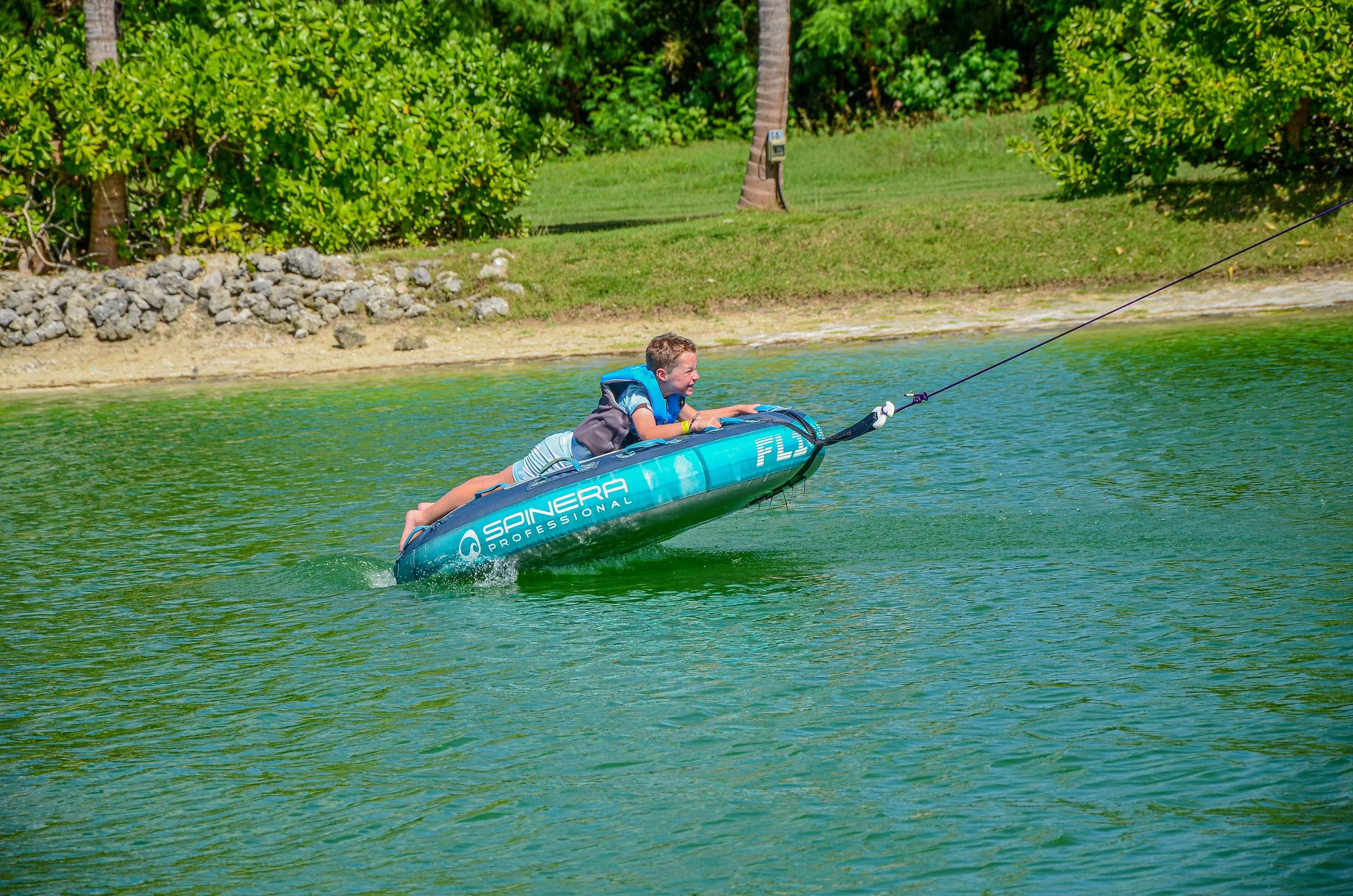 e Kids zip‑lining over the lake at Caribbean Lake Park, Punta Cana