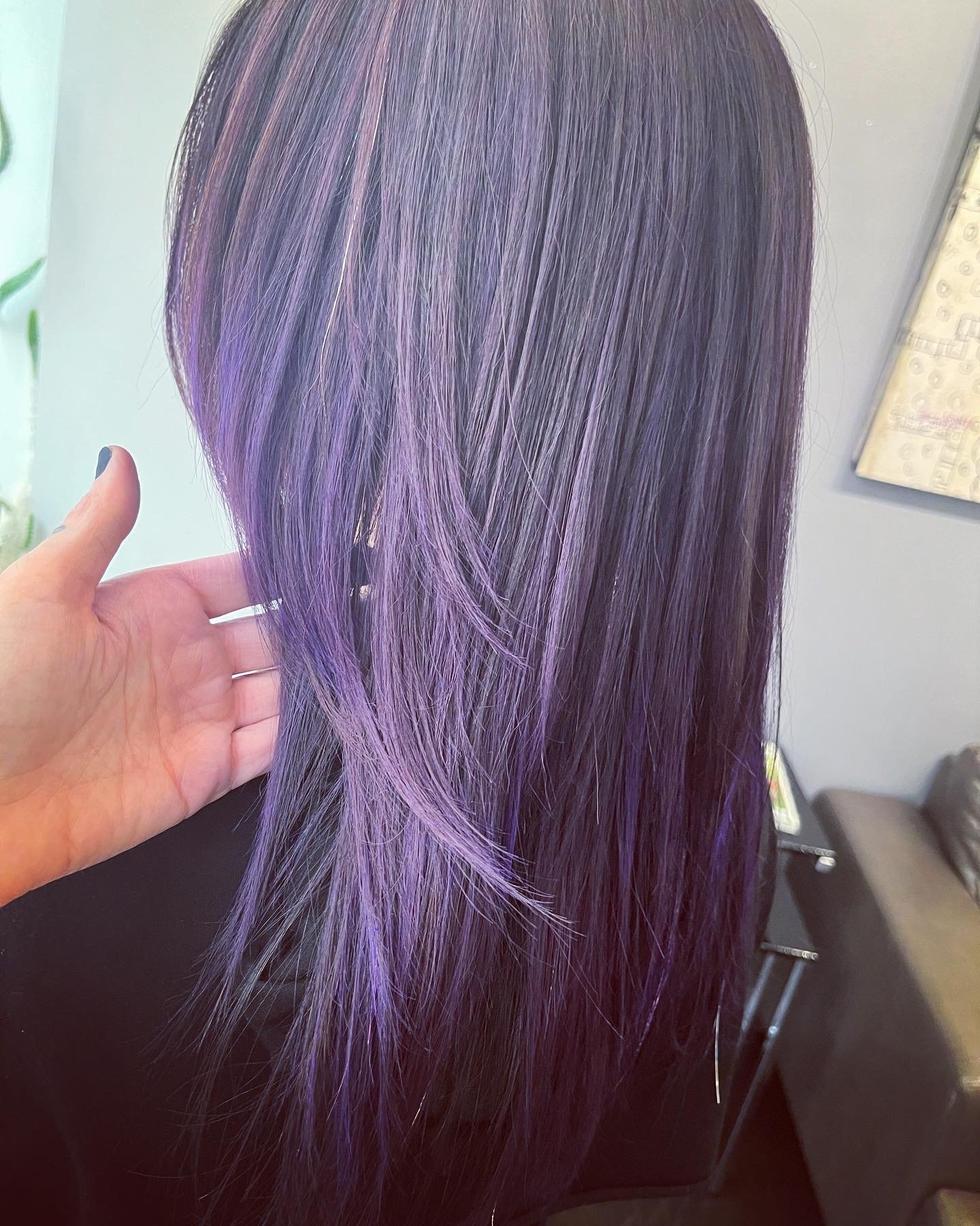 A person's long hair with purple highlights.