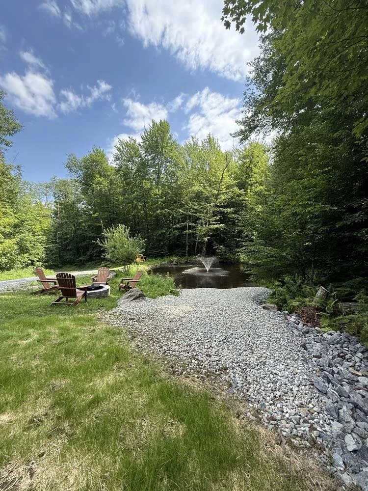 Gravel, a fire pit, and chairs are added.