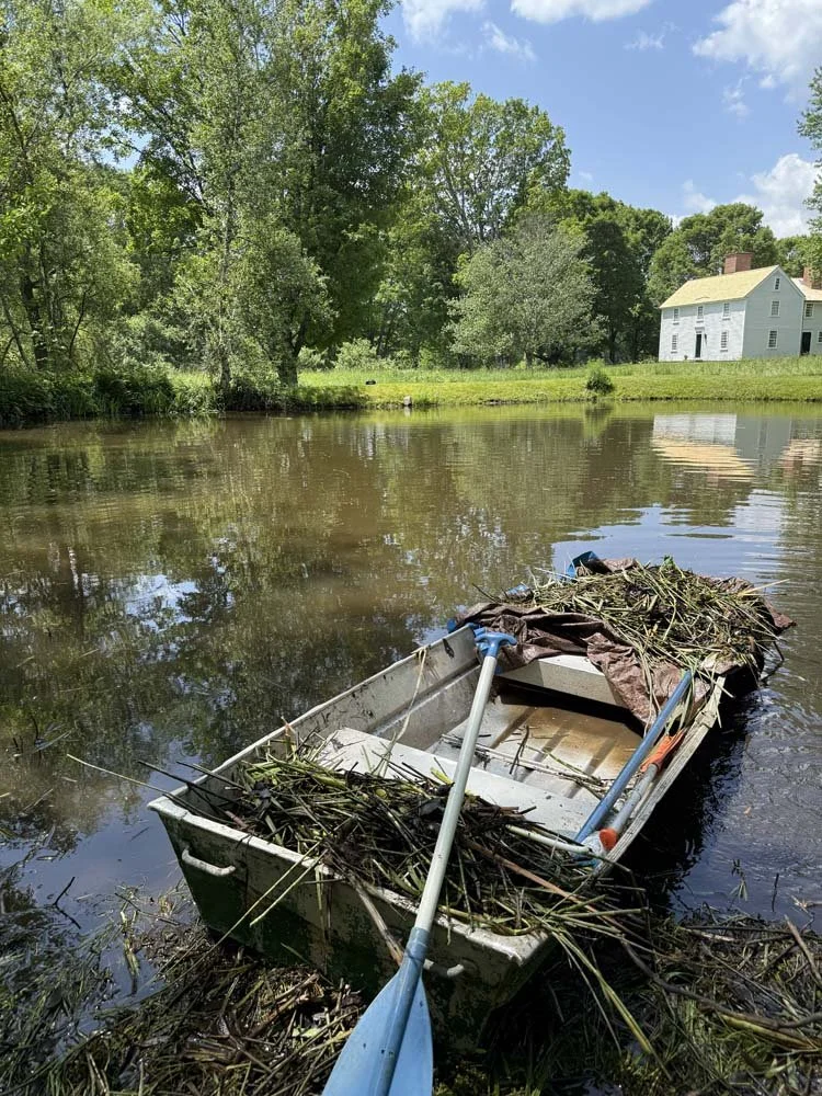 Eric uses a rowboat to pick up debris