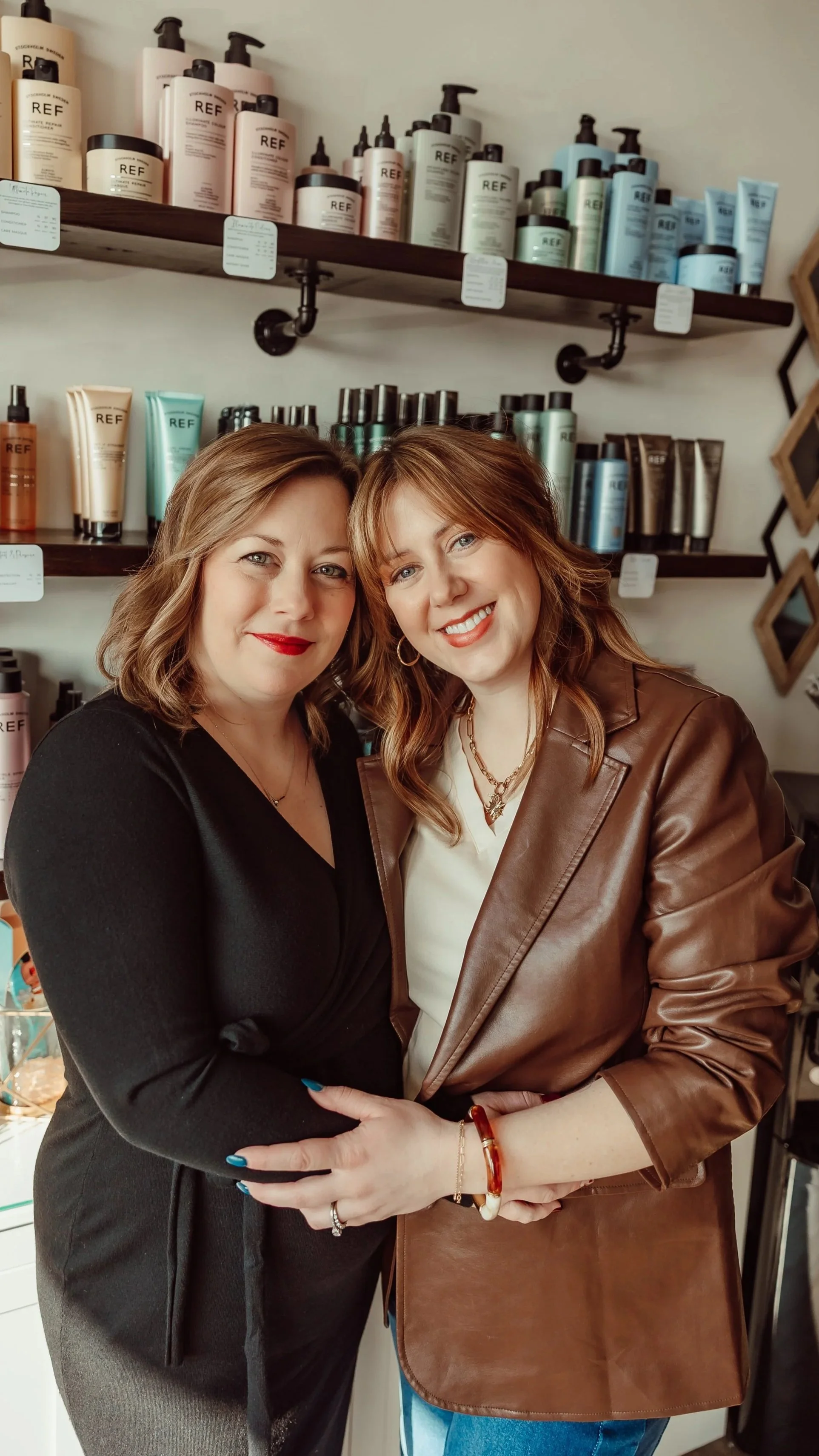 Stylists and owners standing in front of REF product shelf