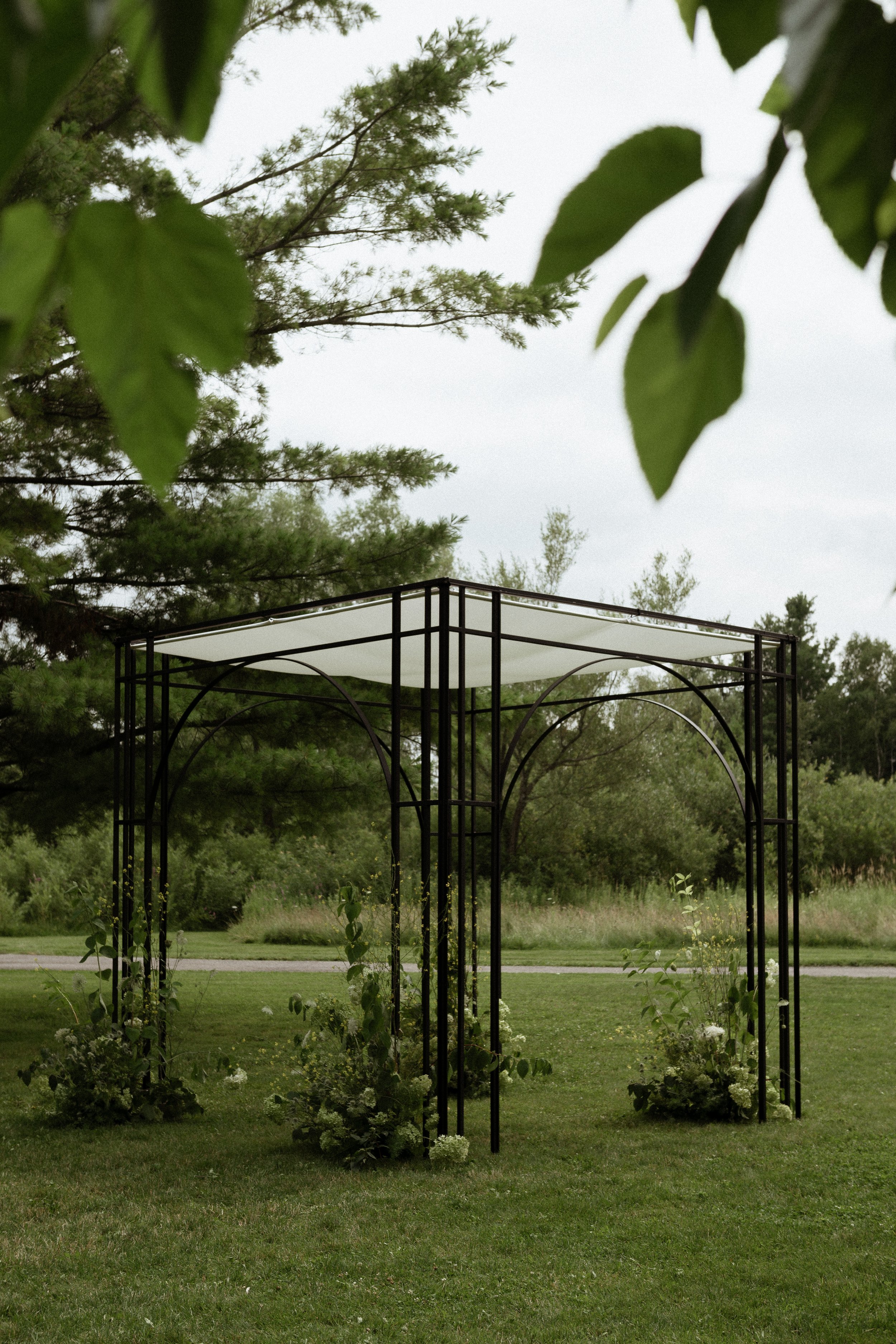 AVILION black chuppah with layered arches and overhead canopy