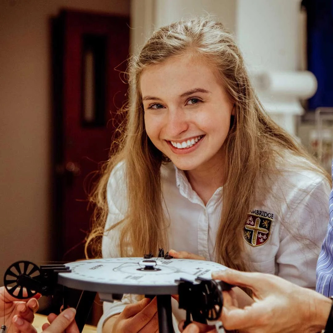 Smiling female high school student wearing the uniform of The Cambridge School of Dallas, a top ranked classical Christian school.