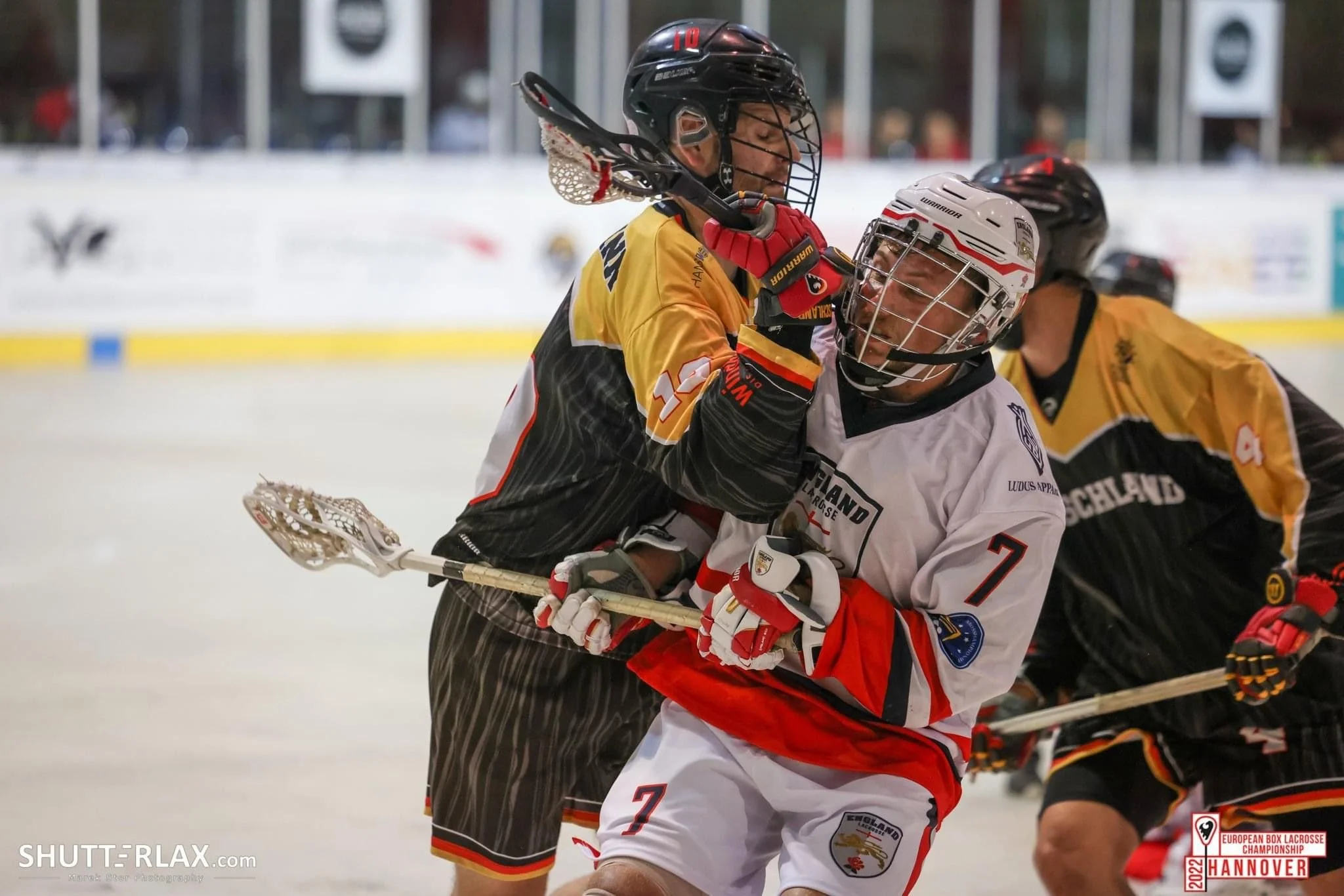 Two players engaging in a box lacrosse match during a European championship game.