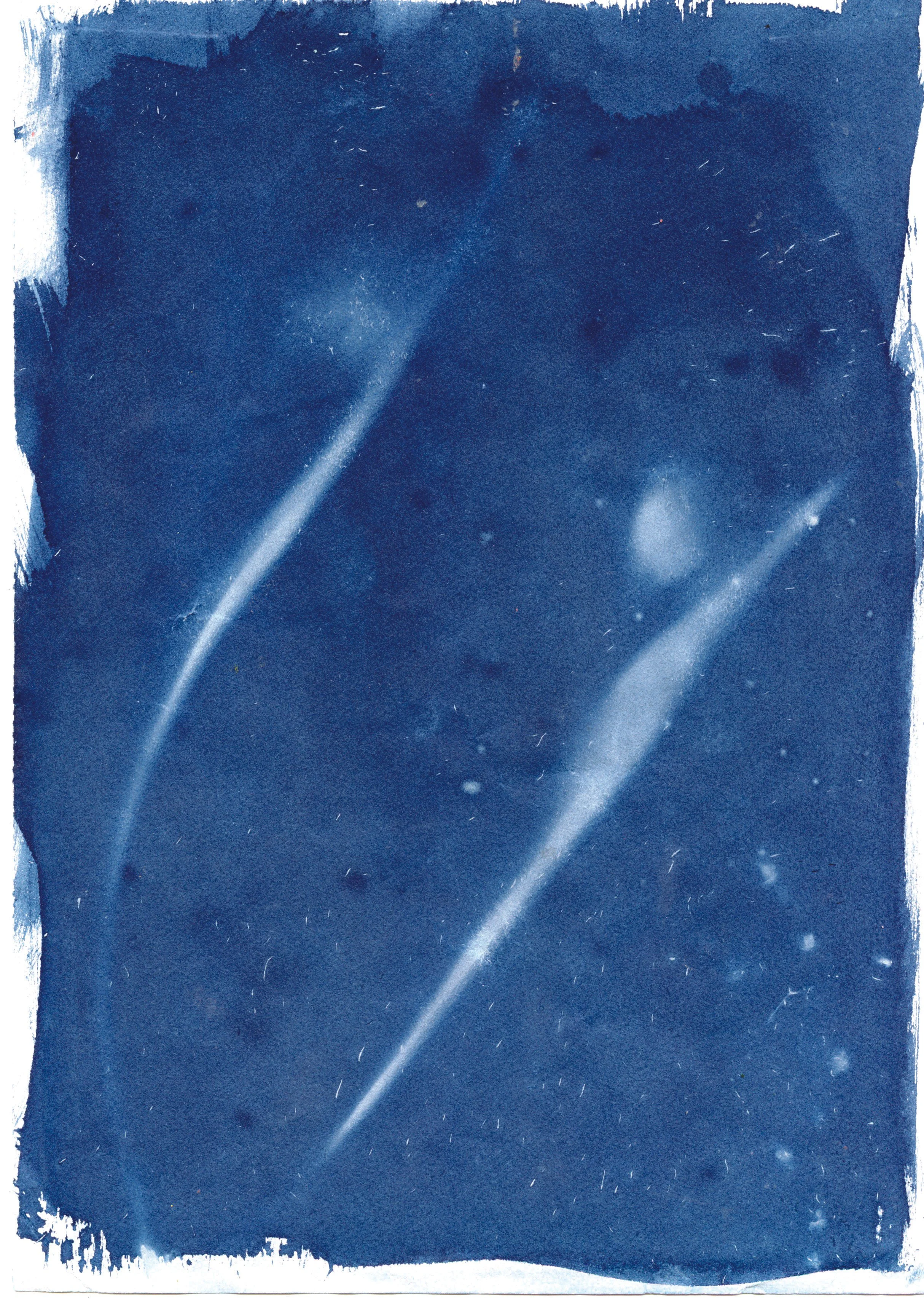 Two shooting stars or meteors streaking across the night sky.