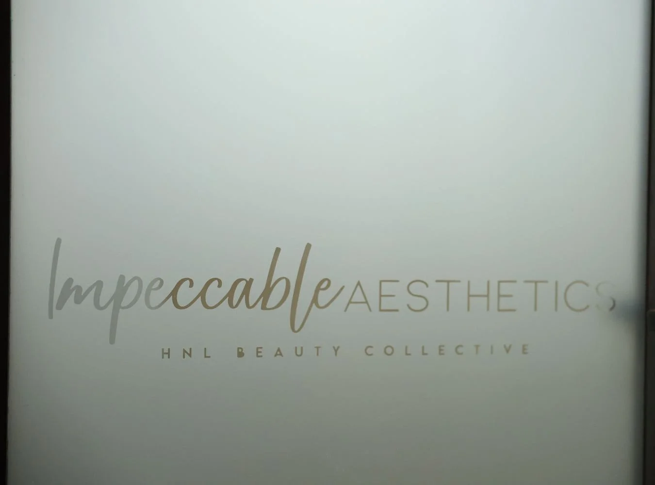 A logo for 'Impeccable Aesthetics' with the subtitle 'HNL Beauty Collective' on a light background.