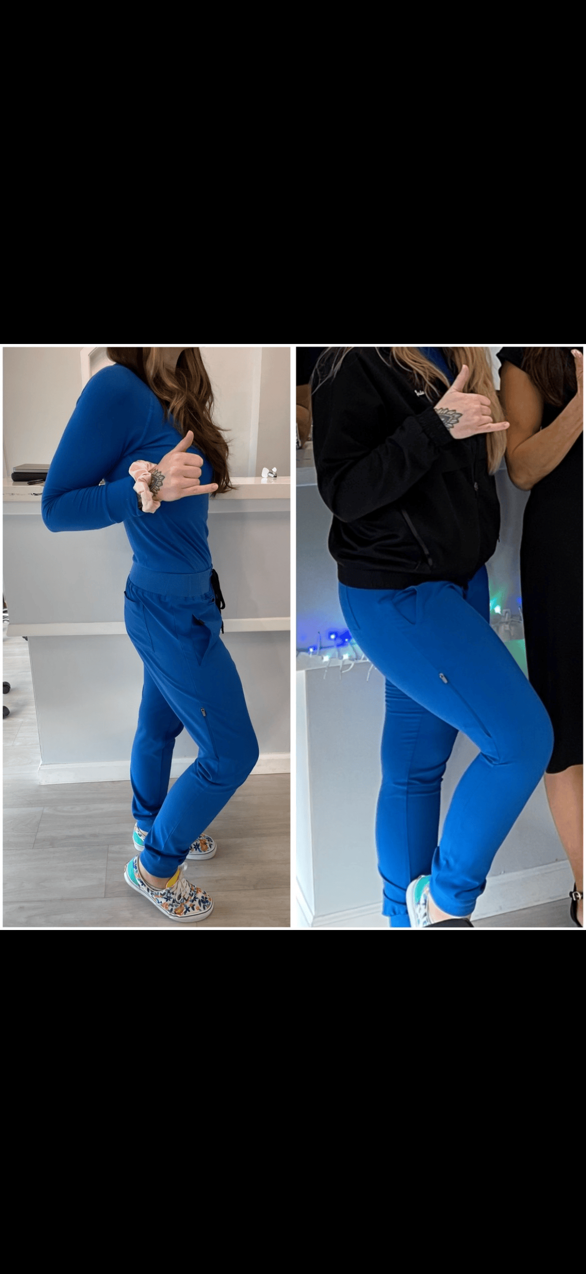 Two women wearing blue pants, one in a blue long-sleeve shirt with a scrunchie on her wrist, the other in a black zip-up hoodie, both making the 'shaka' hand gesture and standing indoors.