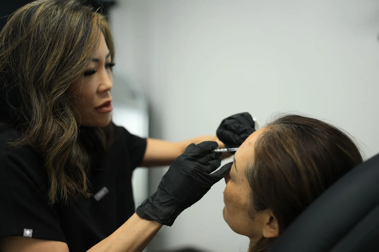 An aesthetic injector injecting Renuva into a patient's temple area.