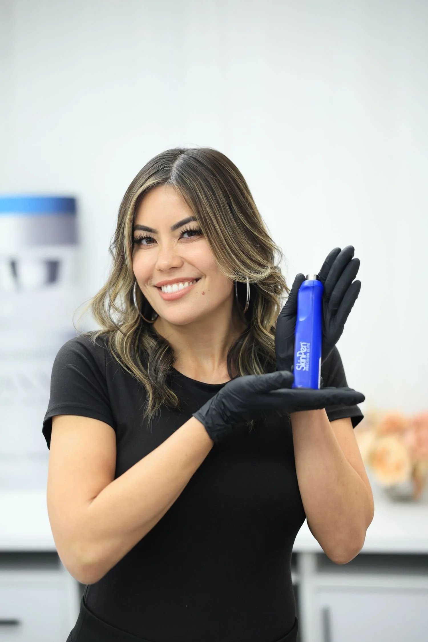 Smiling provider holding SkinPen Precision Elite microneedling device, offering microneedling near Hawaii for natural collagen support.