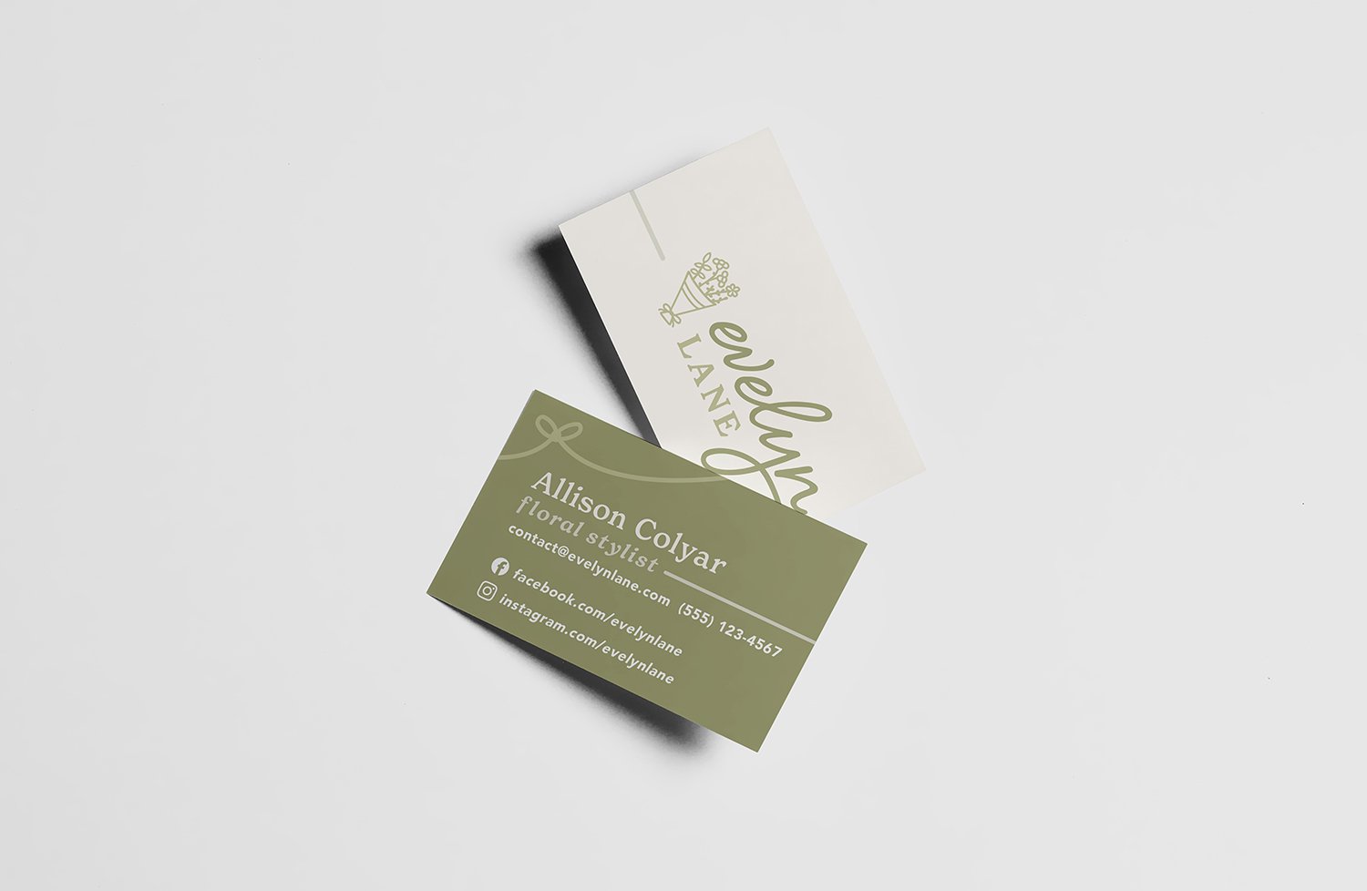 Business cards for a floral stylist, Alison Colyar, on a white surface. One card is dark green with white text, and the other is white with green text.