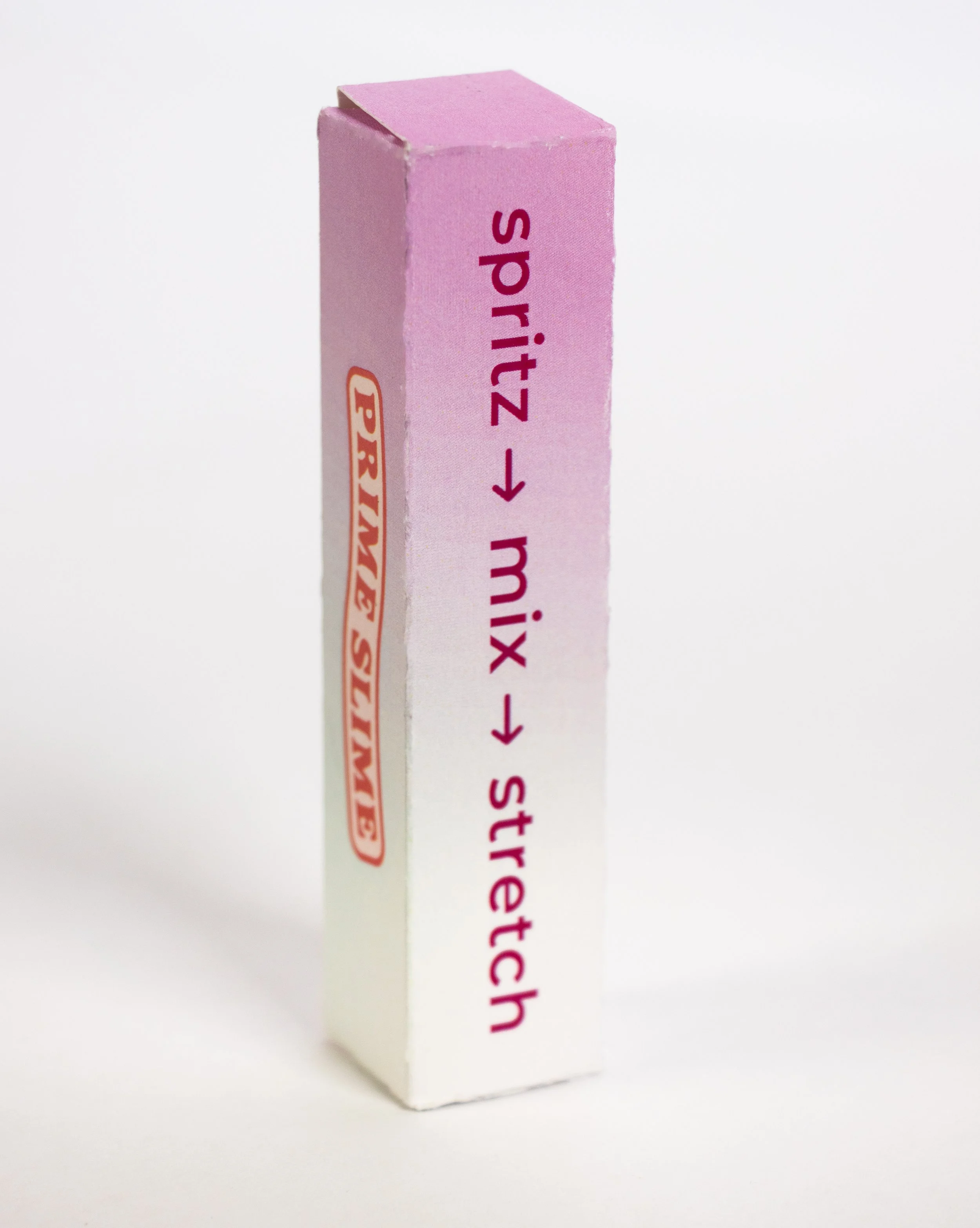 A lip gloss container with pink and white packaging and instructions for applying on the side.