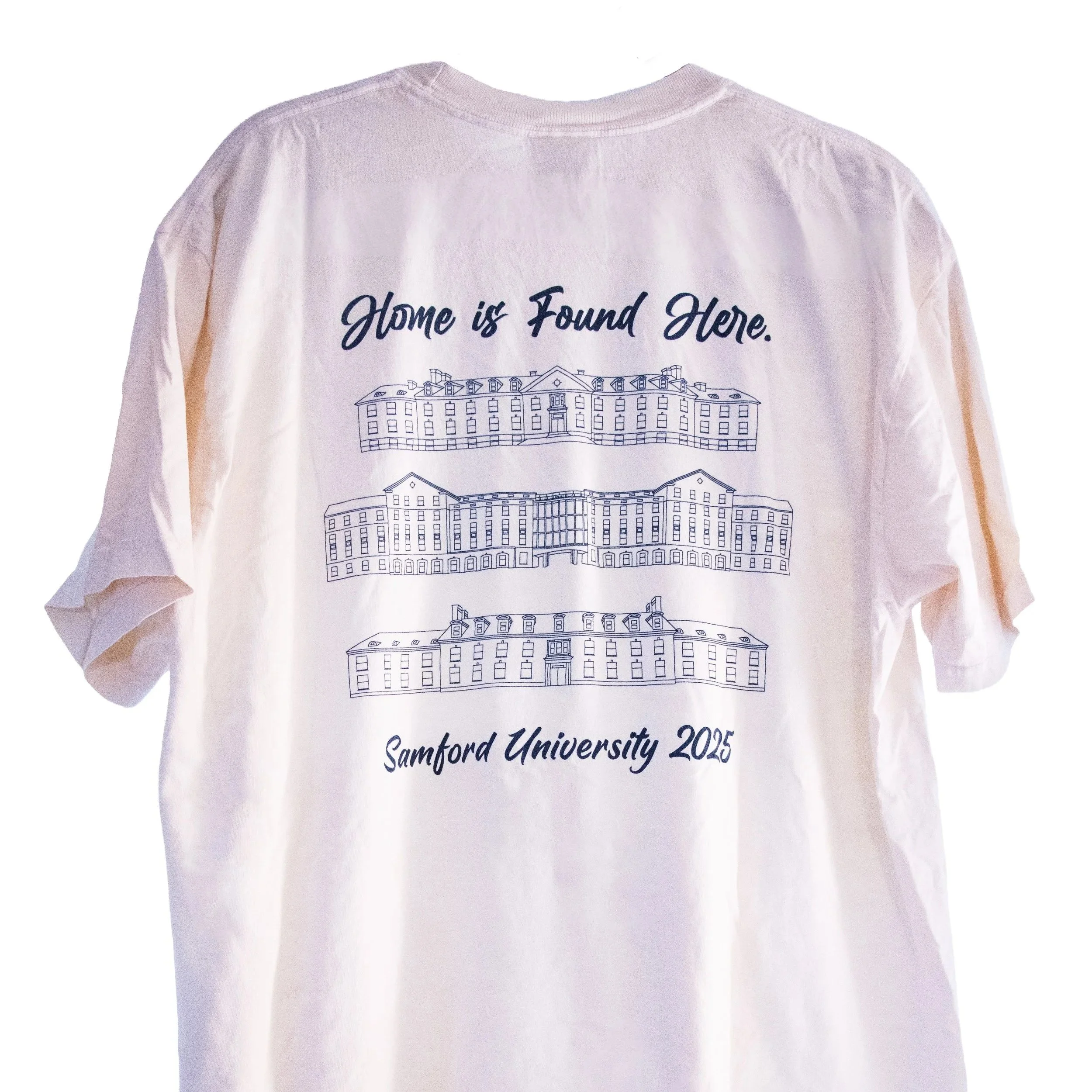White T-shirt with a university campus illustration and the text 'Home is Found Here. Samford University 2025' printed on the back.