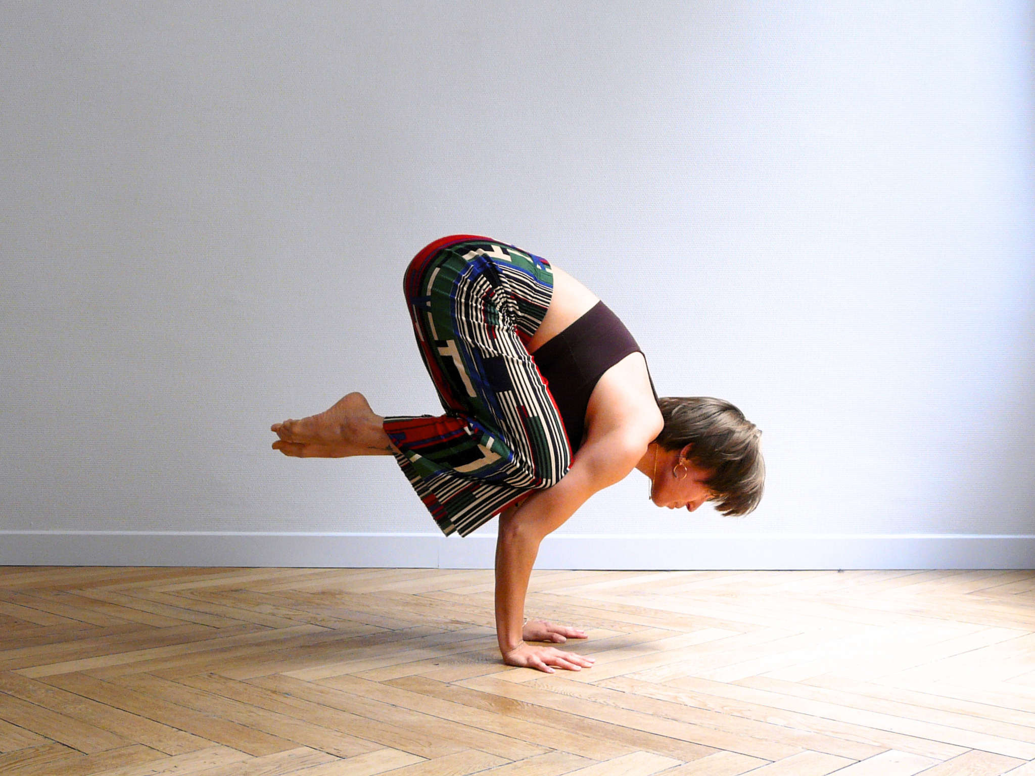 Camille en train d'effectuer une posture de Yoga s'appelant la posture du corbeau