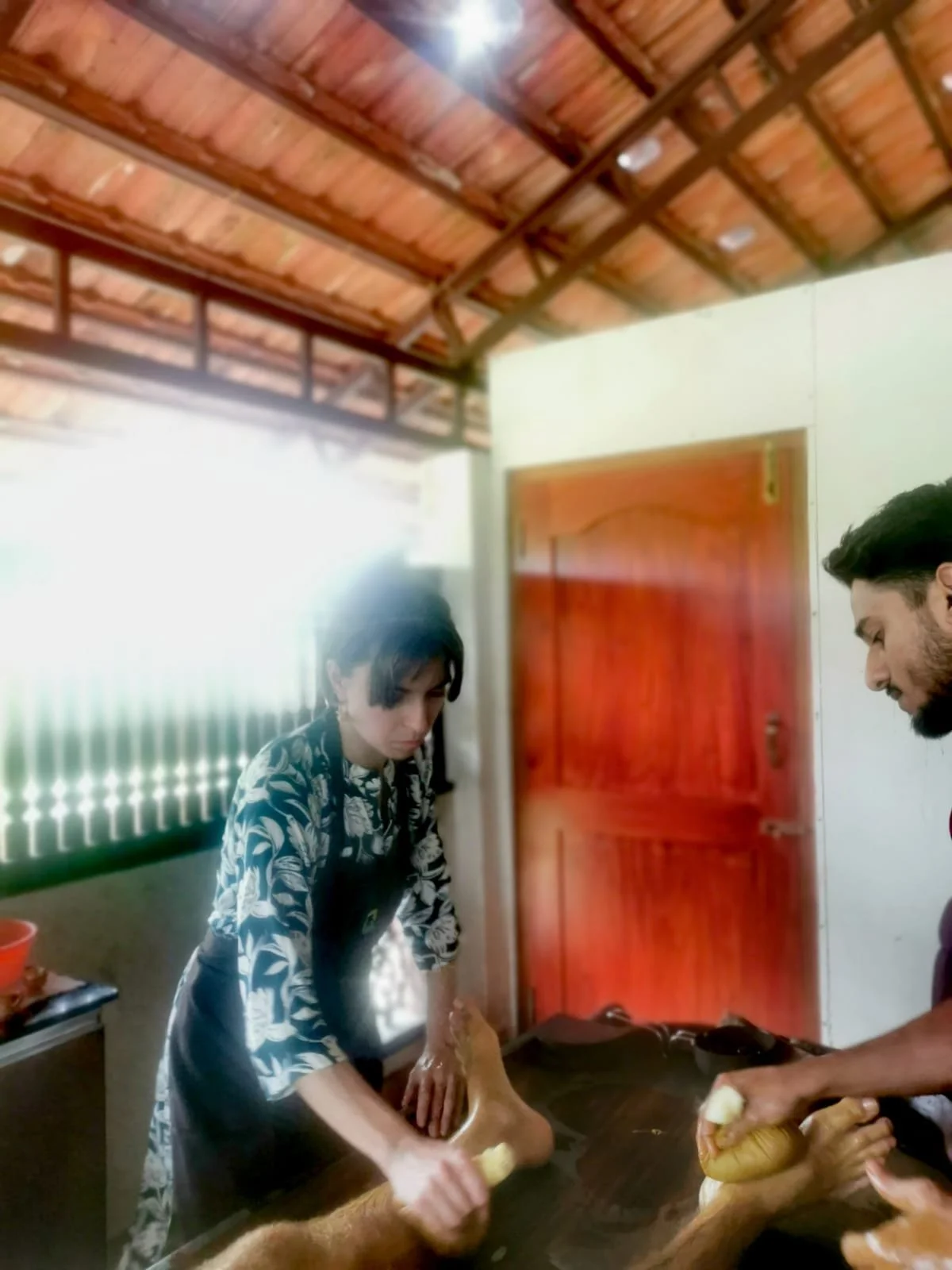 Camille en stage en Inde en train de masser accompagnée par un professeur