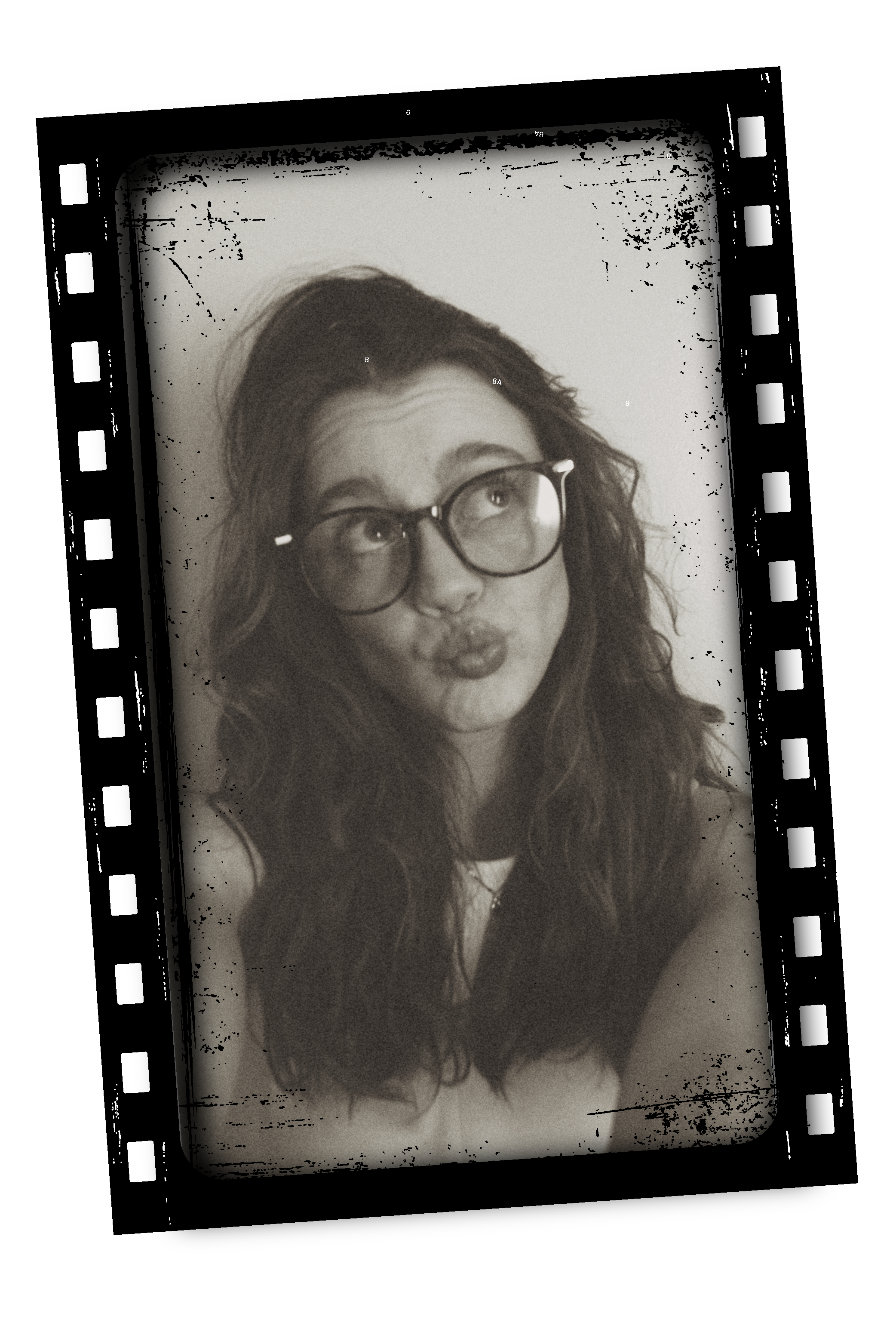 Black and white photo of a woman with curly hair and glasses making a kiss face, displayed on a screen.