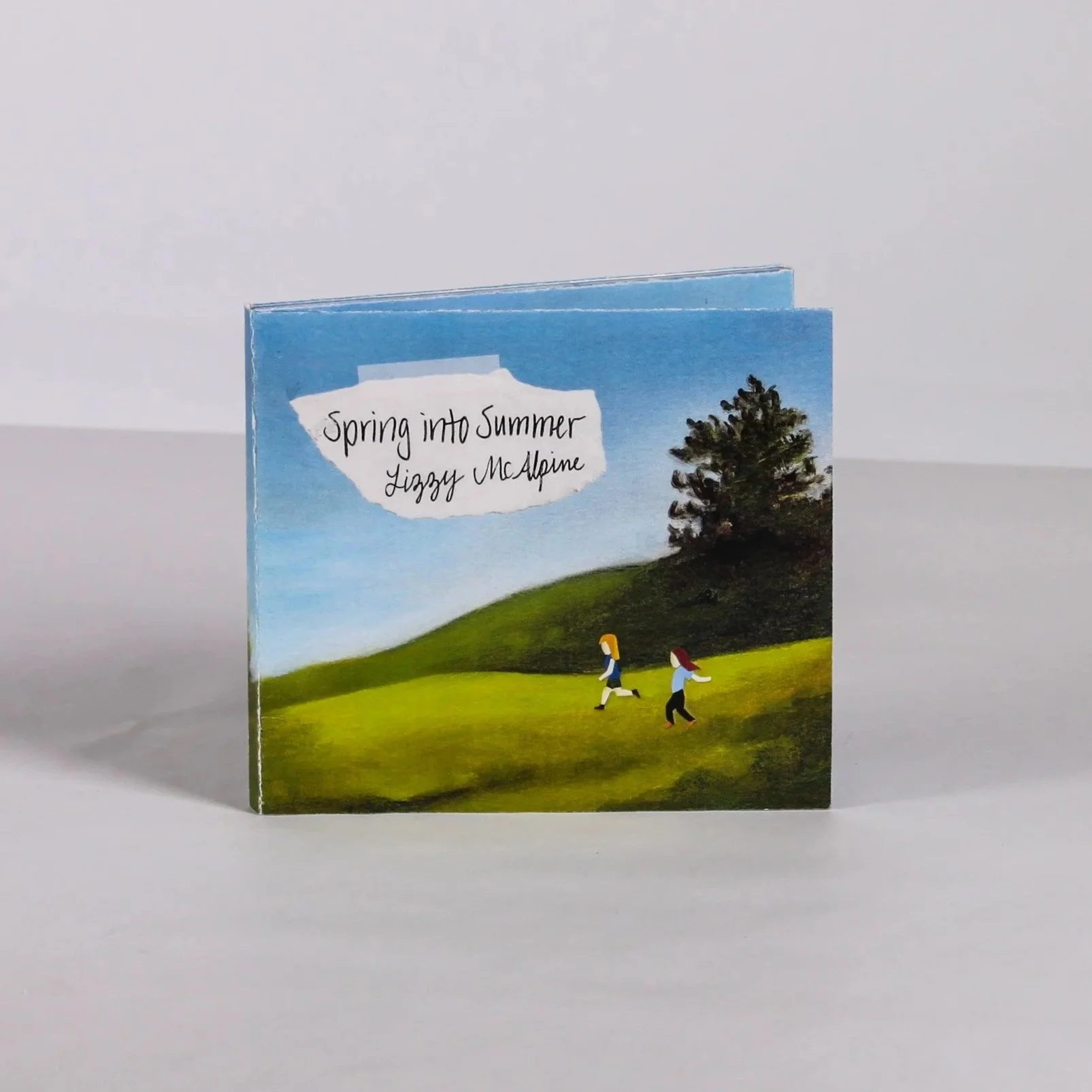 CD cover with the text "Spring into Summer Lizzy McAlpine" over a painting of a green hillside with two girls running.