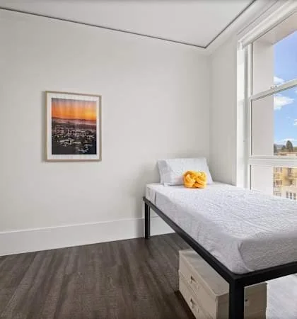 A made-up single bed in a spare room, the place many men end up sleeping.