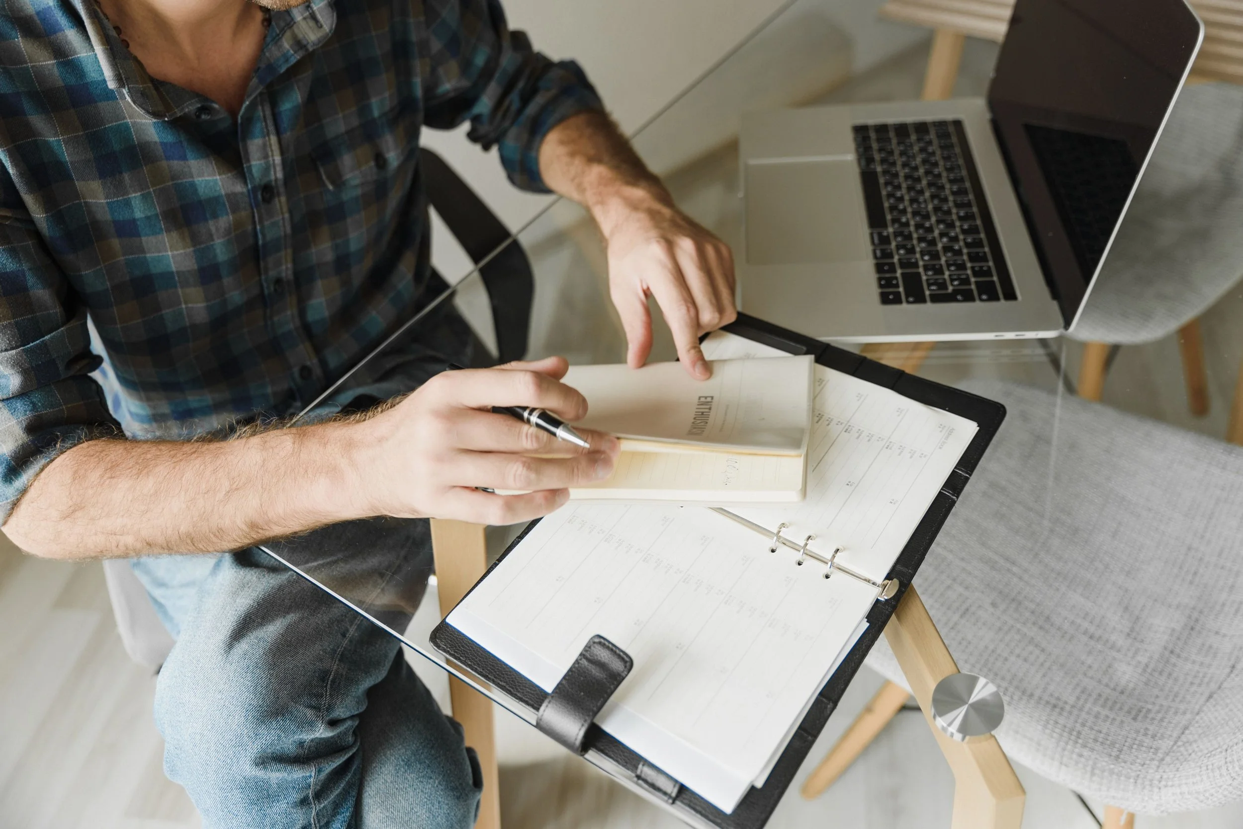 A person closing a notebook after writing at a desk.