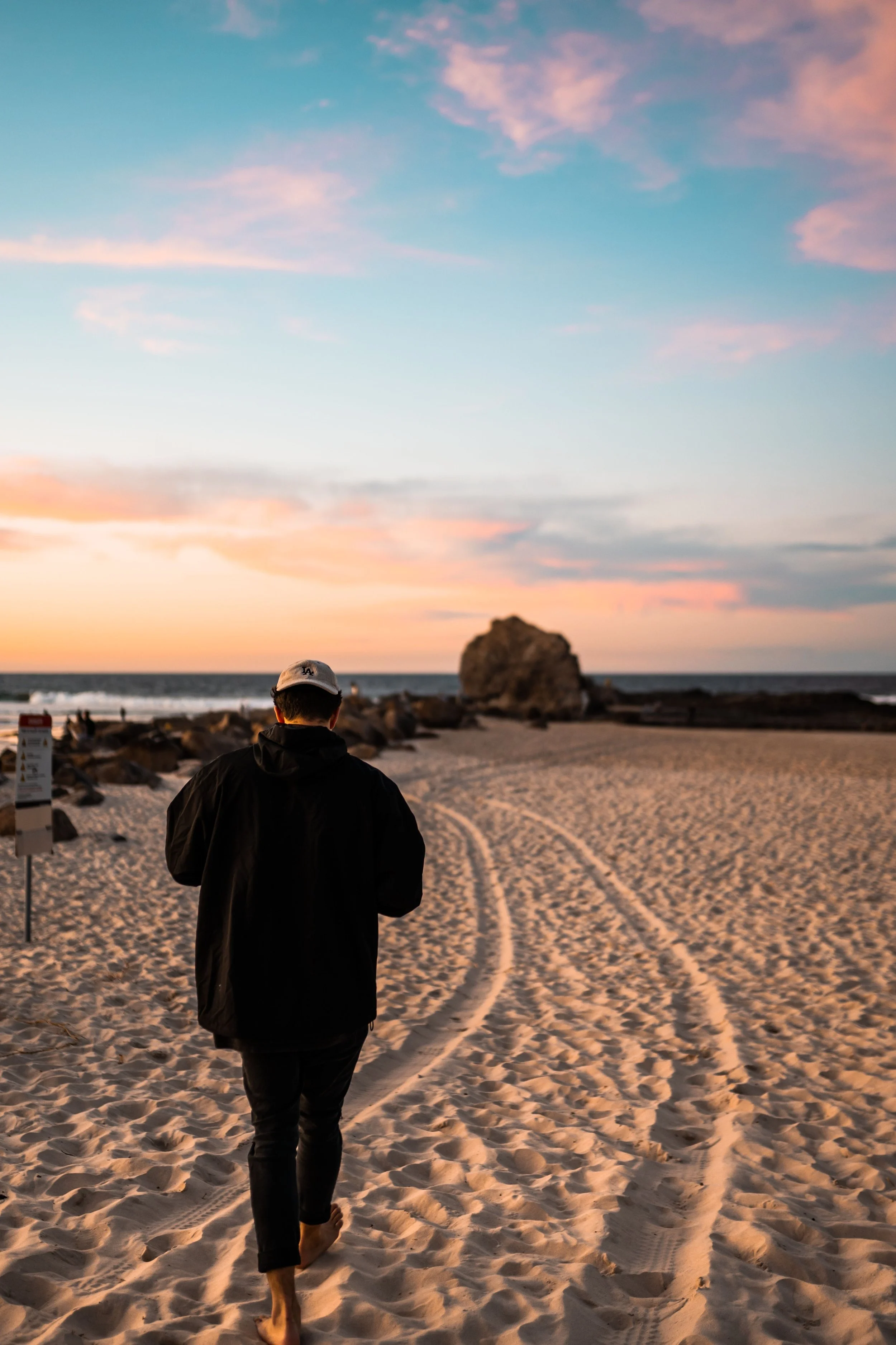 Man walking alone along a beach at sunset while rebuilding his identity after divorce