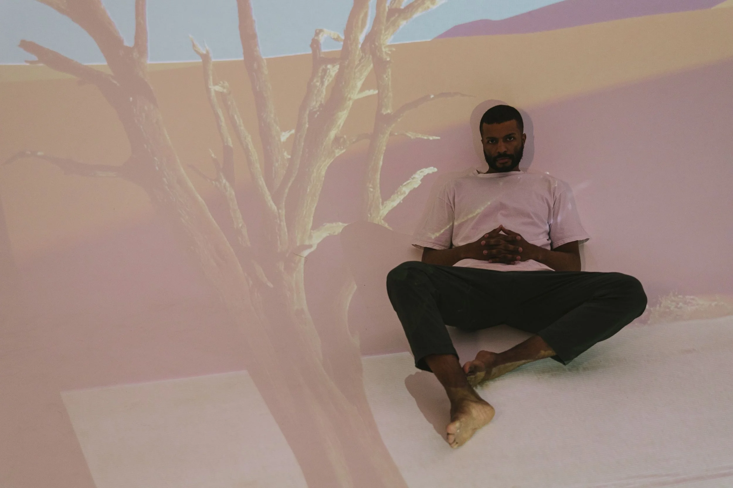 Contemplative man sitting with clasped hands in a shadowed room