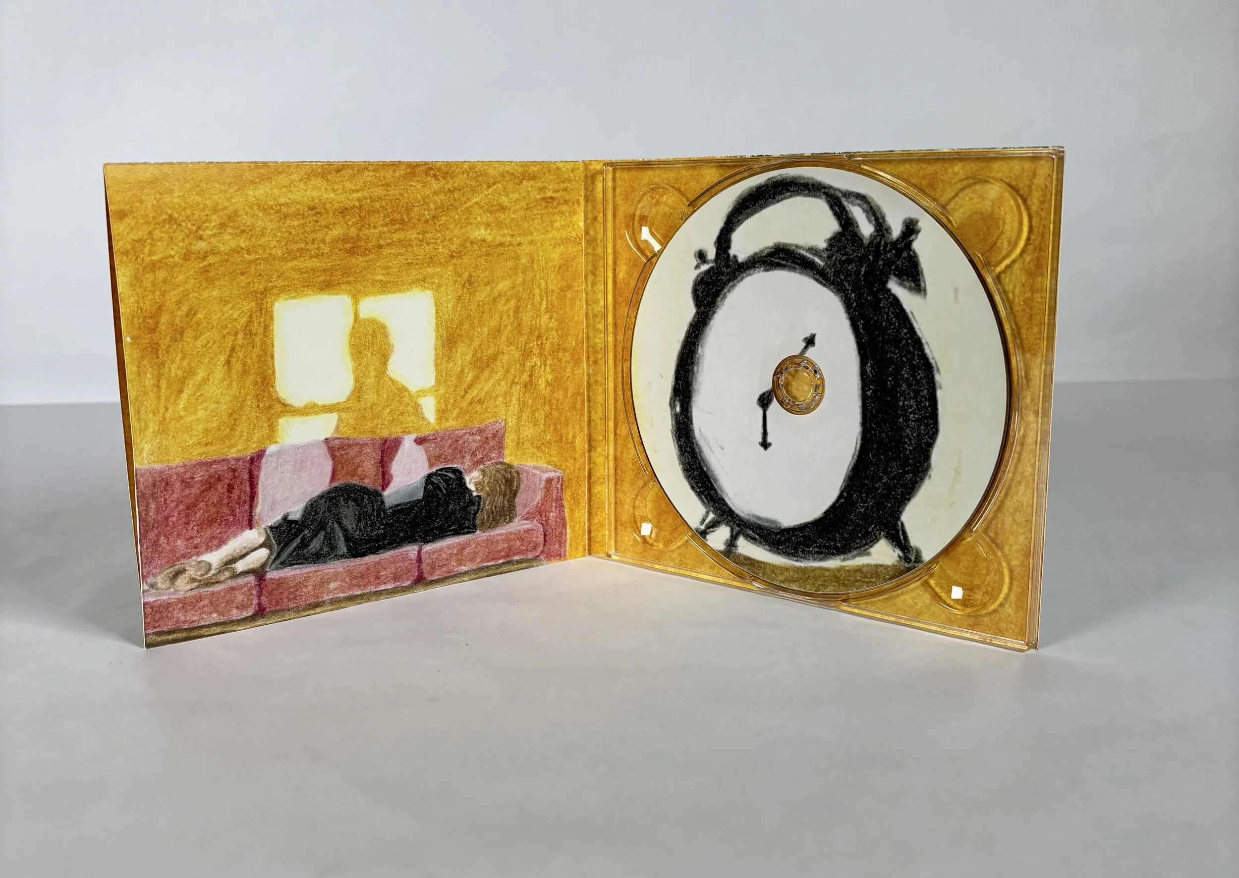 CD case with artwork depicting a woman lying on a sofa and a clock with exaggerated black hands.