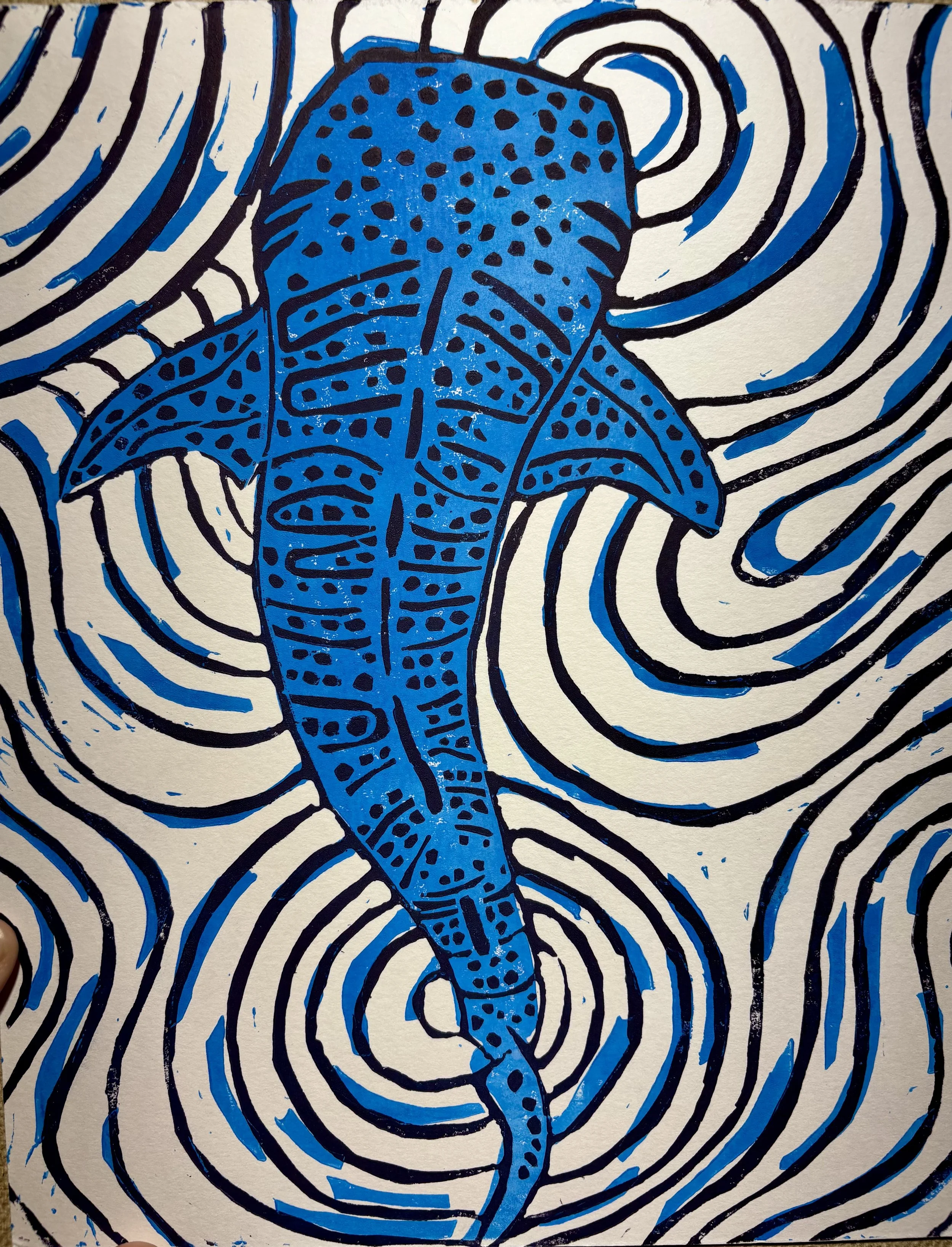 A stylized illustration of a blue whale with black and white lines swirling around it.