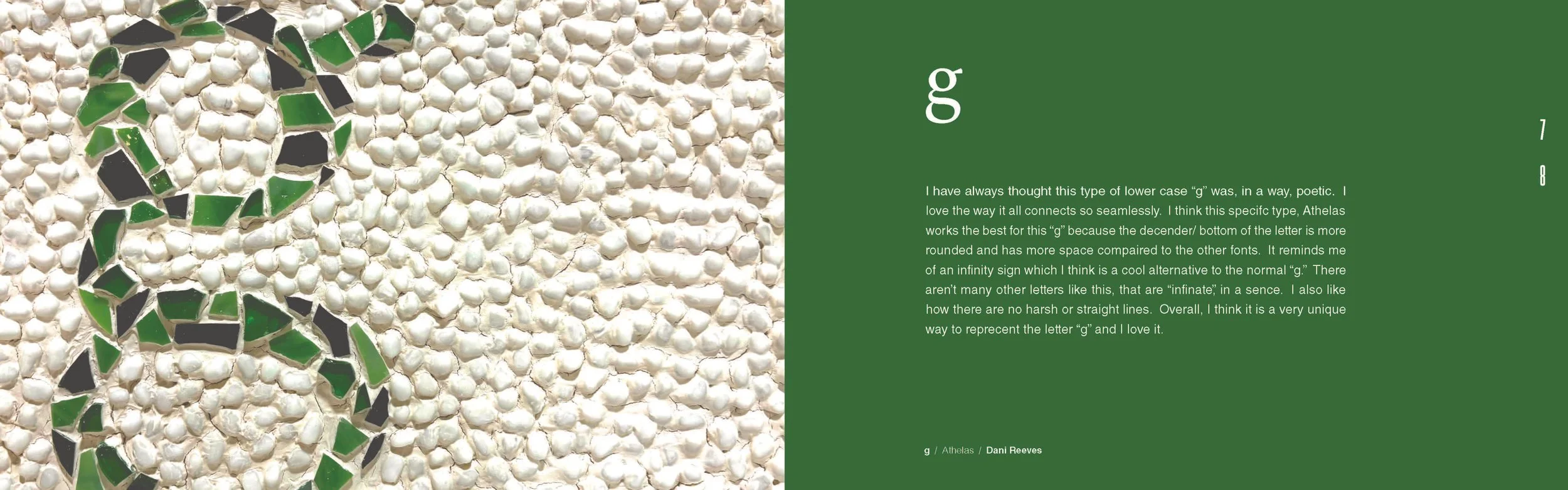 Close-up of a mosaic design with green and black tiles on a white pebble background, forming the letter 'g'.