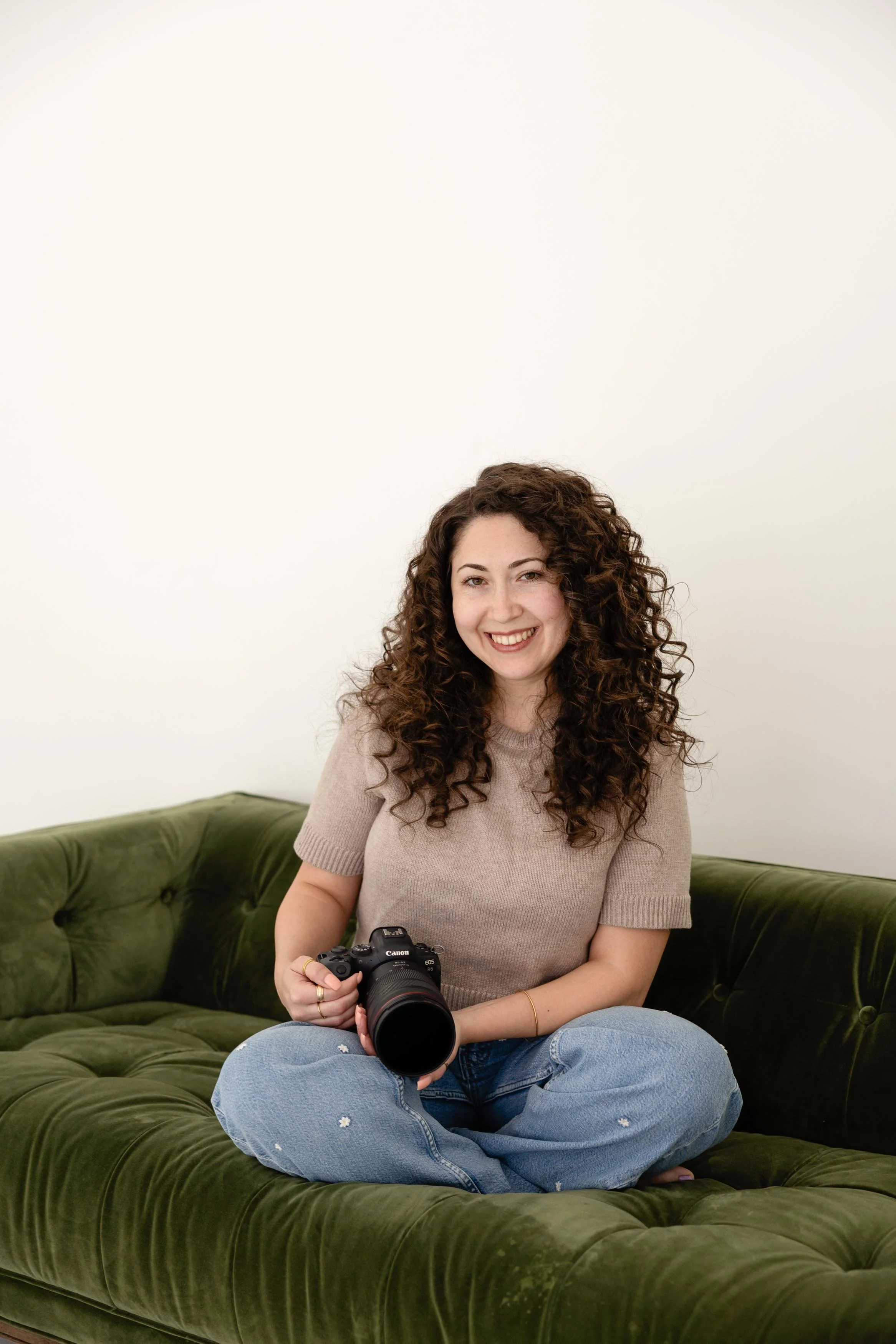 Lady with camera sitting on green couch