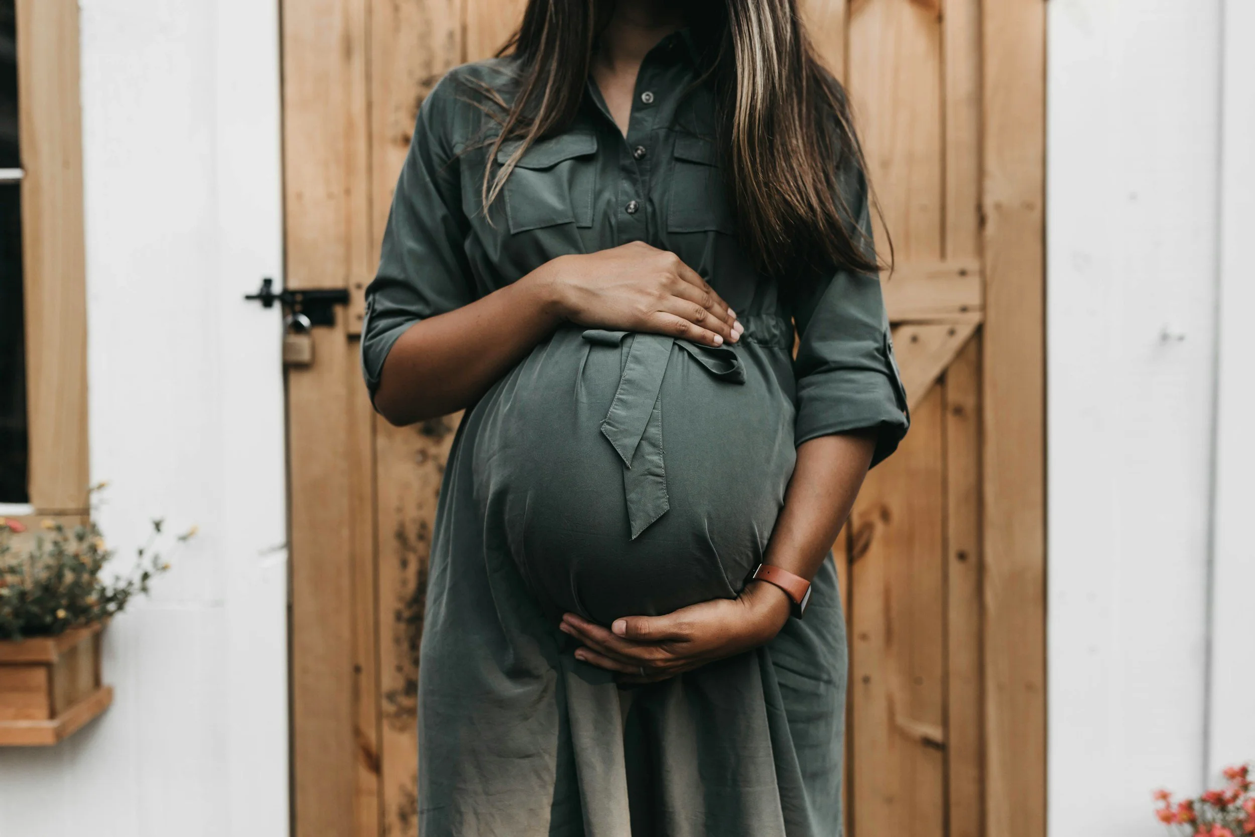 Pregnant woman in green dress holding belly image for pricing page childbirth class in Alpharetta GA