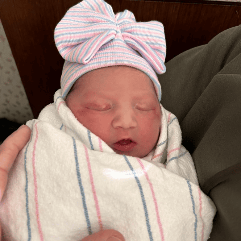newborn baby girl swaddled with bow after birth unmedicated hospital birth story Alpharetta GA