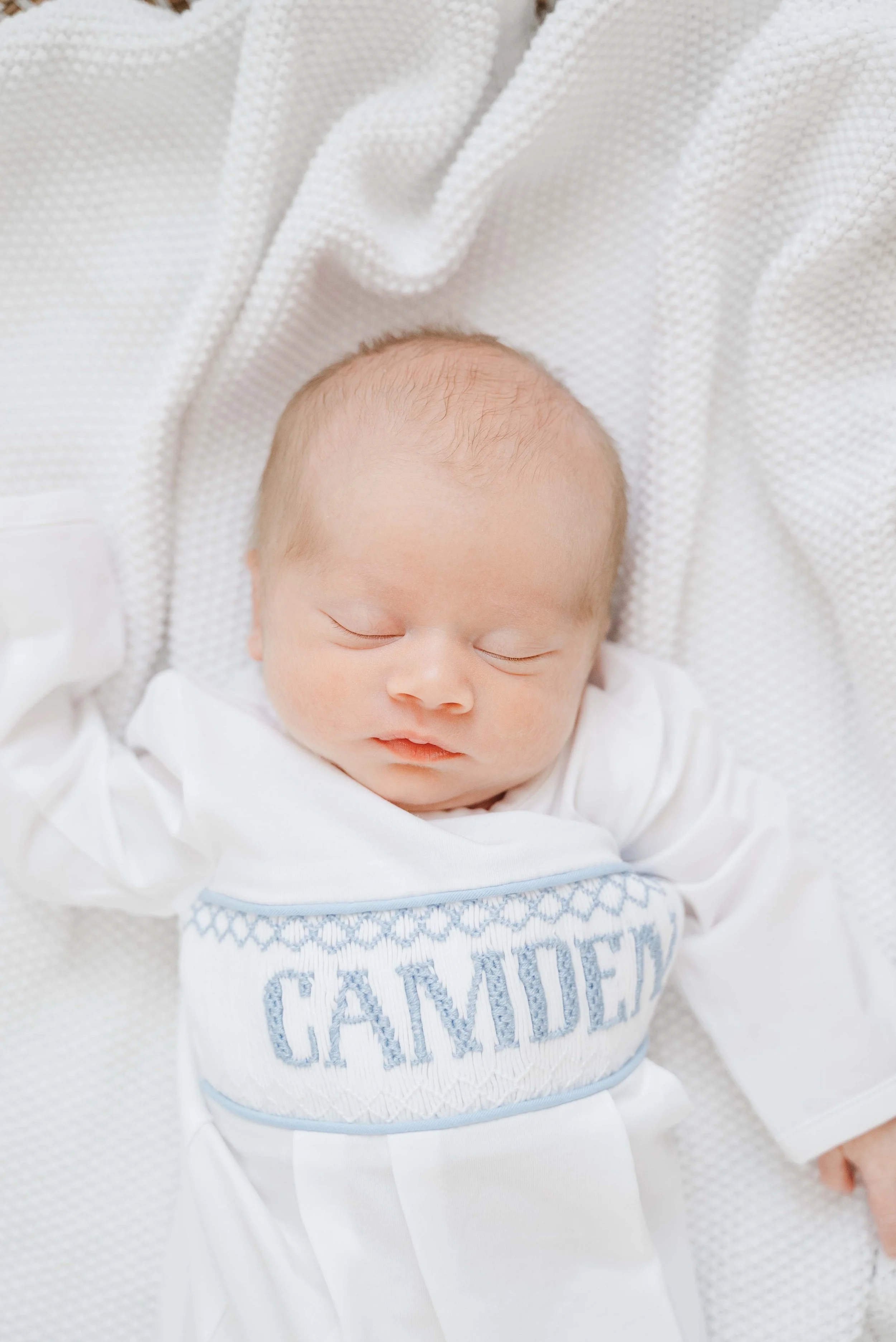 newborn photo of baby boy on white blanket