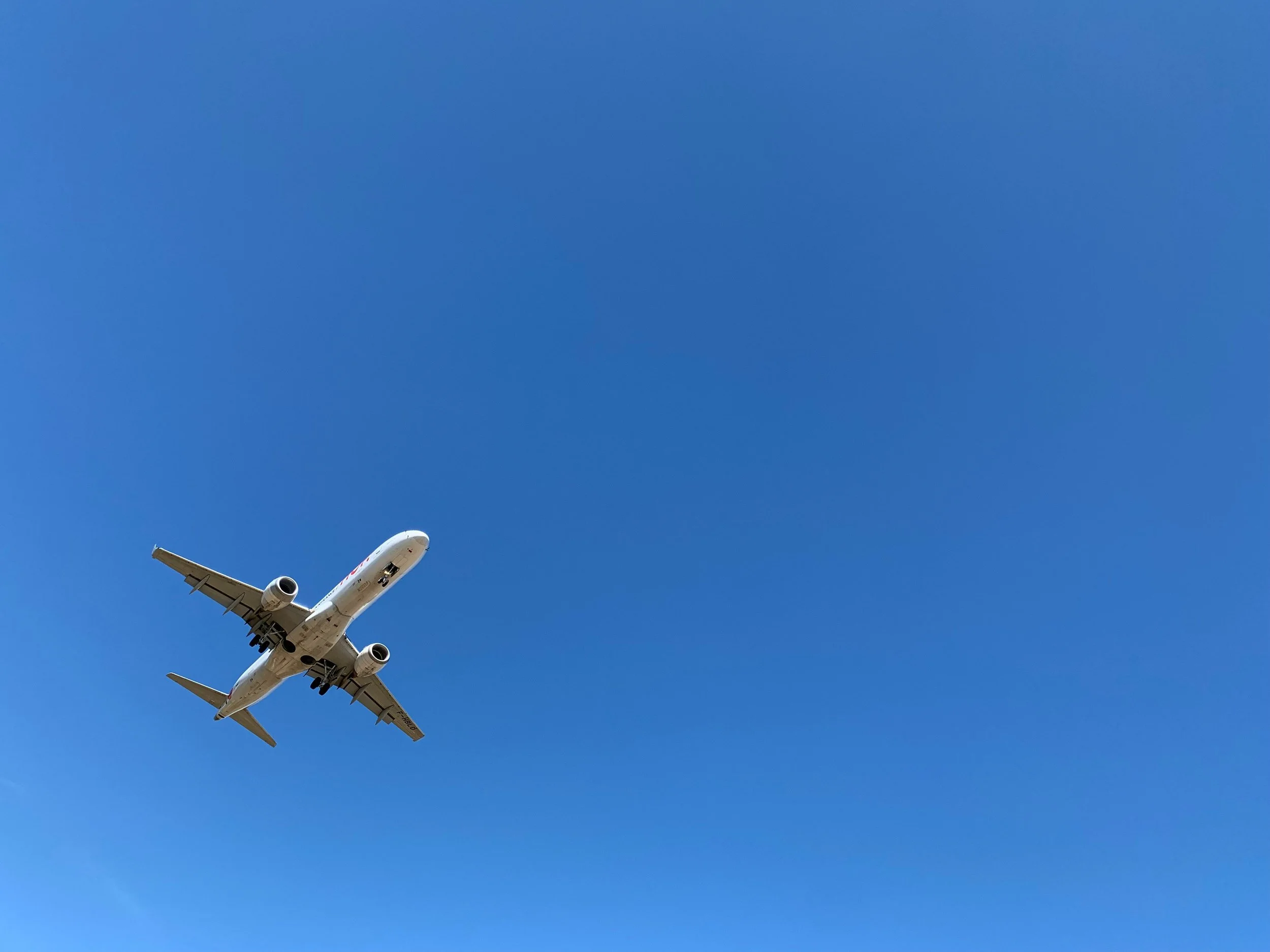 Avión volando en cielo azul despejado.
