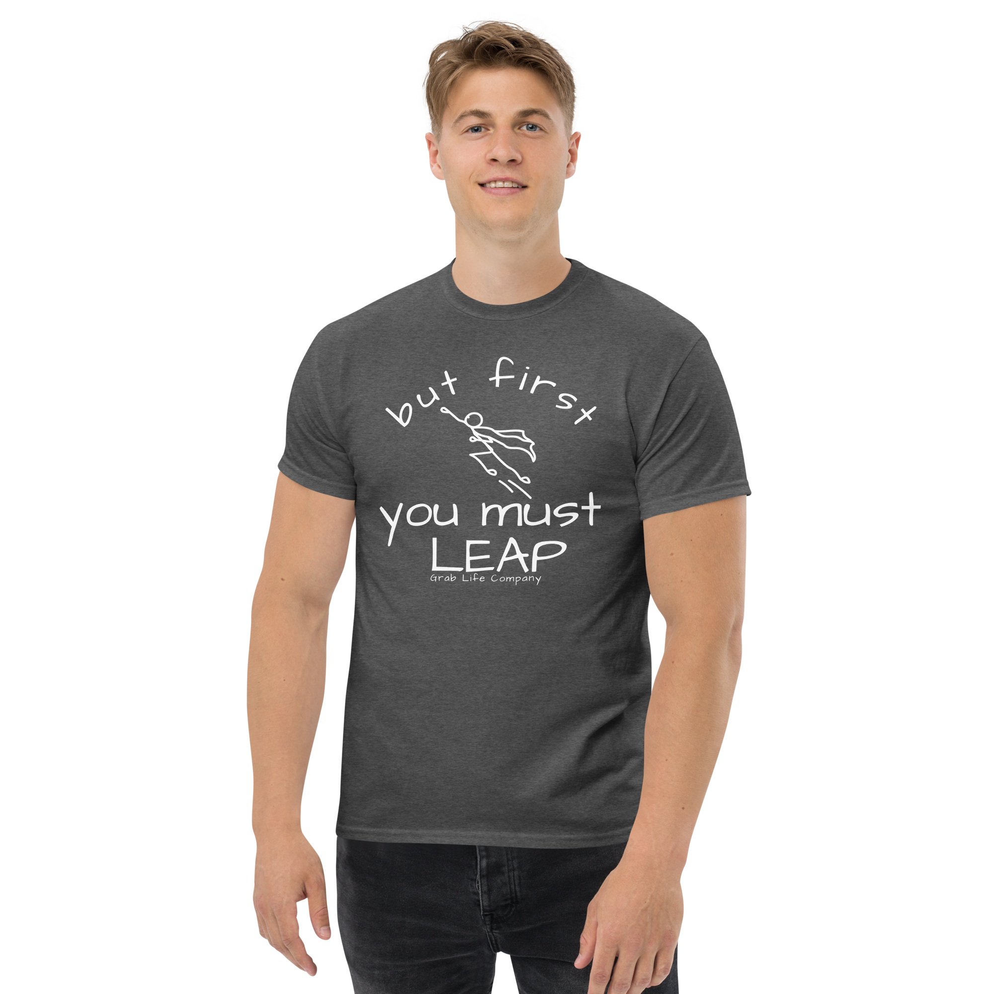 Grab Life Company t-shirt with But First You Must LEAP printed in white on front of dark heather grey shirt. Image shows a man wearing the dark heather grey shirt.