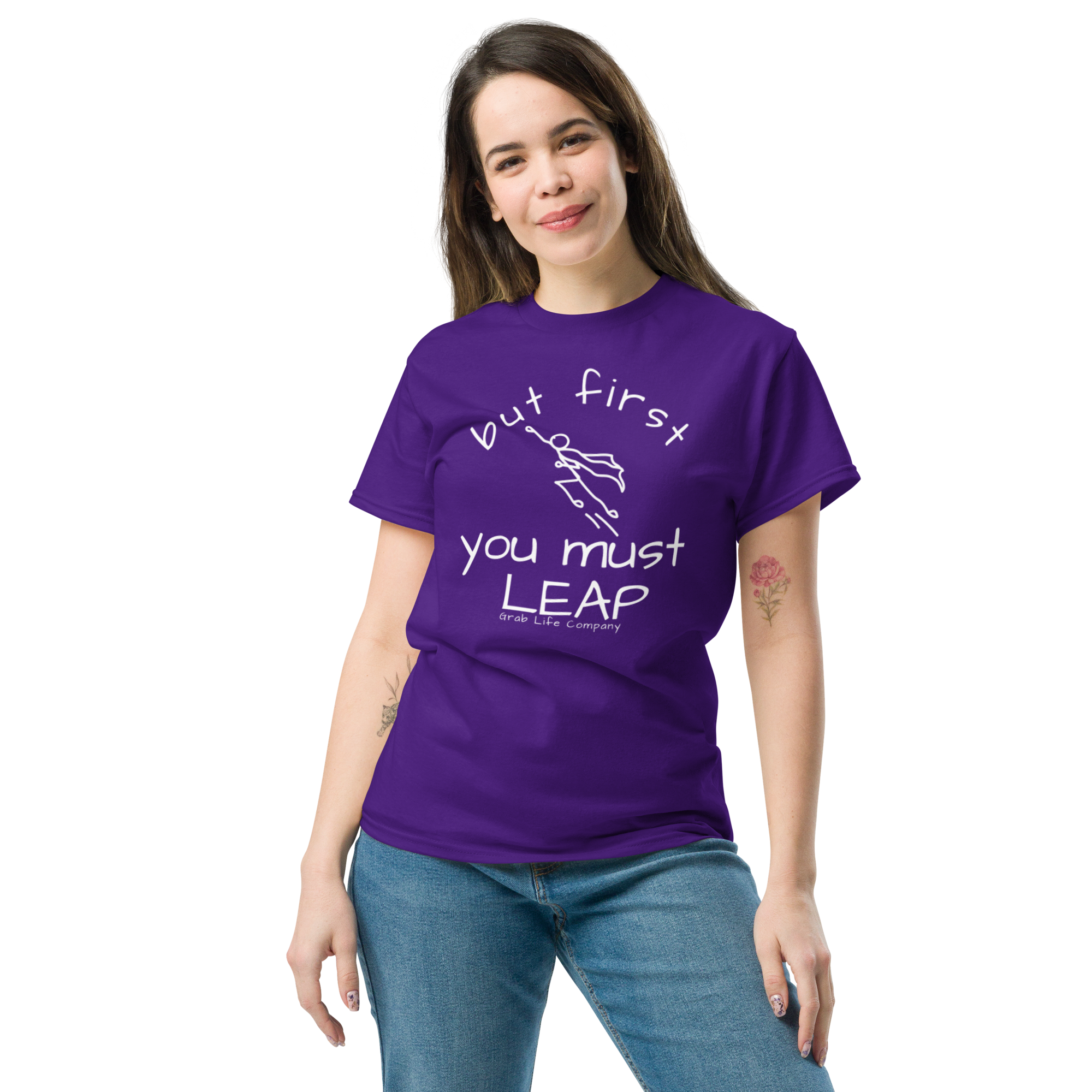 Grab Life Company t-shirt with But First You Must LEAP printed in white on front of purple shirt. Image shows a woman wearing the purple shirt.