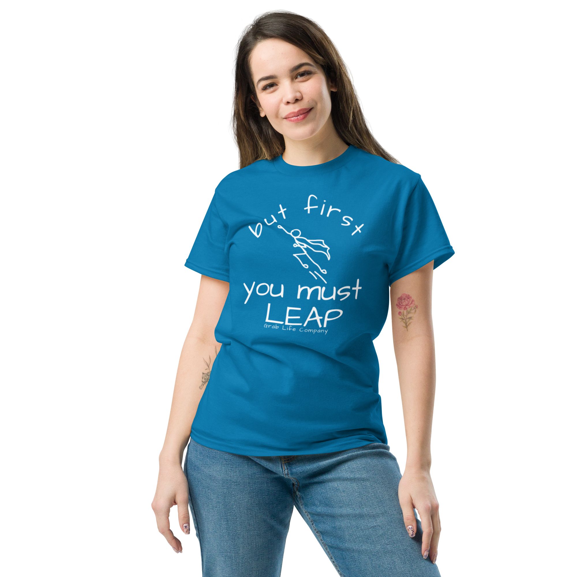 Grab Life Company t-shirt with But First You Must LEAP printed in white on front of sapphire blue shirt. Image shows a woman wearing the sapphire blue shirt.